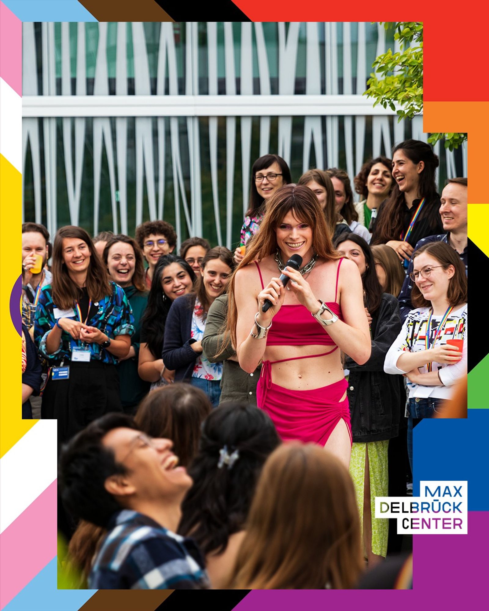 A photo taken during the "Pride After Hour" at the MDC Pride Symposium 2023 shows people on the 3rd-floor terrace observing a performance artist. © Felix Petermann, Max Delbrück Center