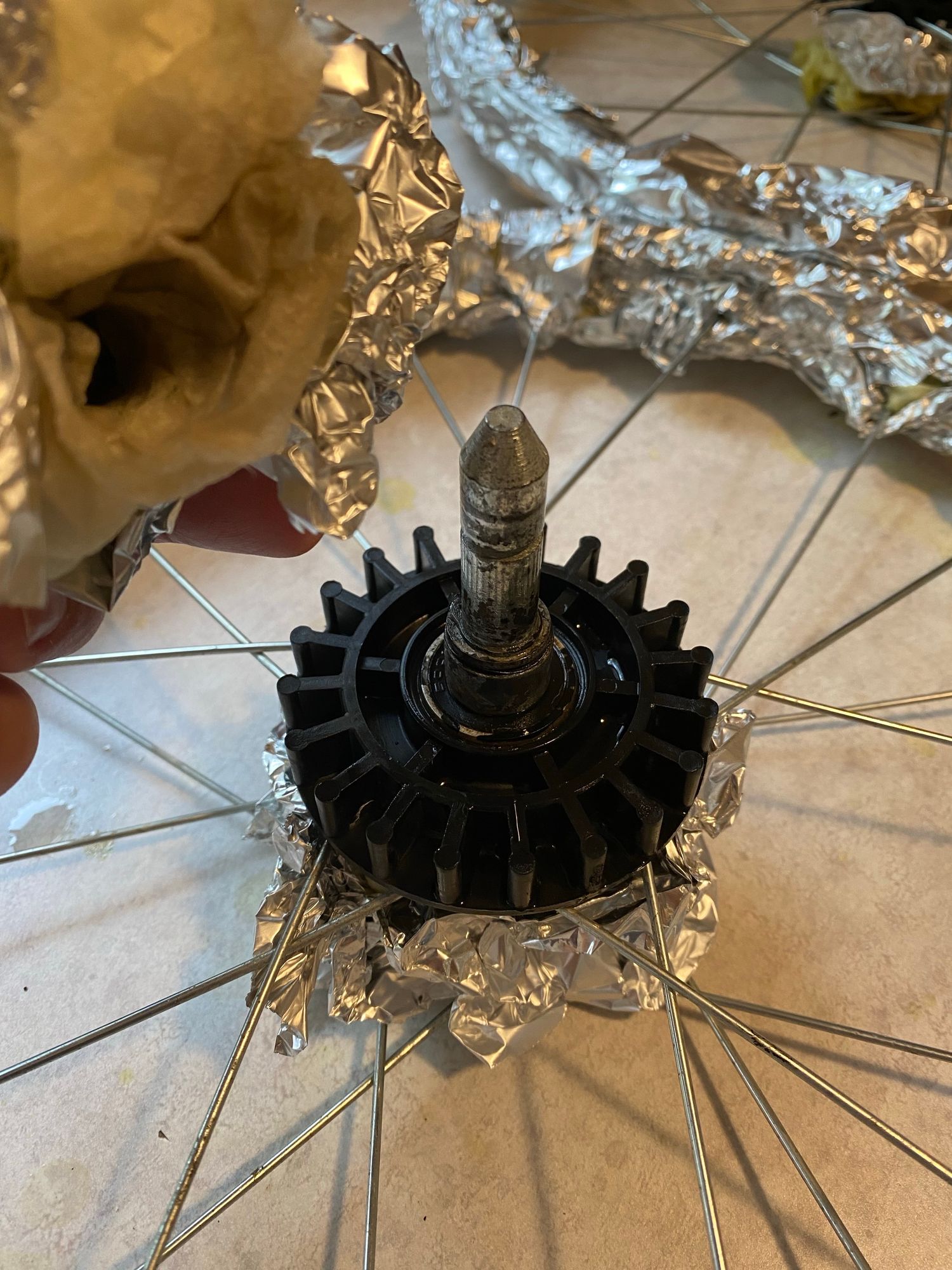 hub and axle of a bike trailer wheel, still dirty but much less so and also less rusty 