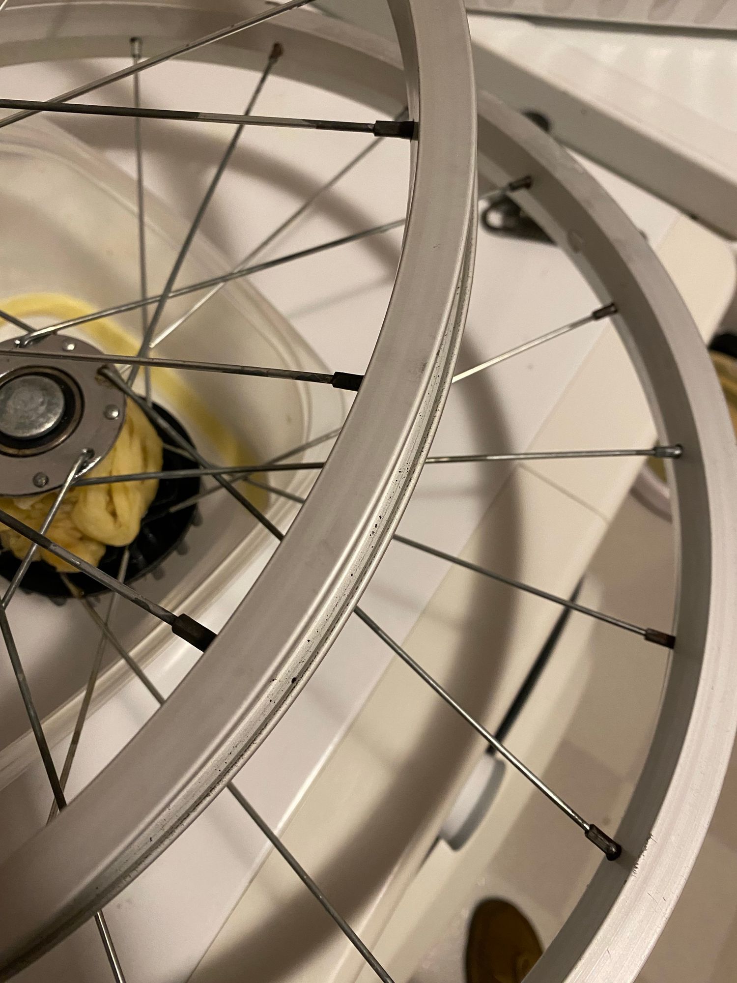 two bike trailer wheels with no-longer-rusted spoke connectors around the rims