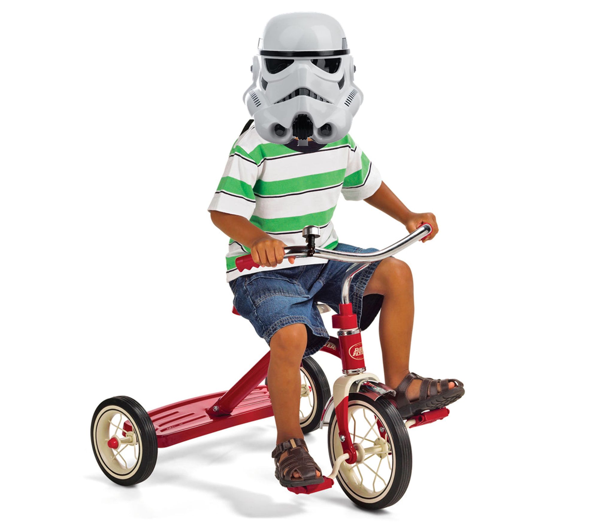 A stock photo of a cute grinning kid (wearing a shirt with broad green and white horizontal stripes, denim shorts, leather sandals) on a red tricycle, with a Star Wars stormtrooper helmet superimposed over the kid's head.