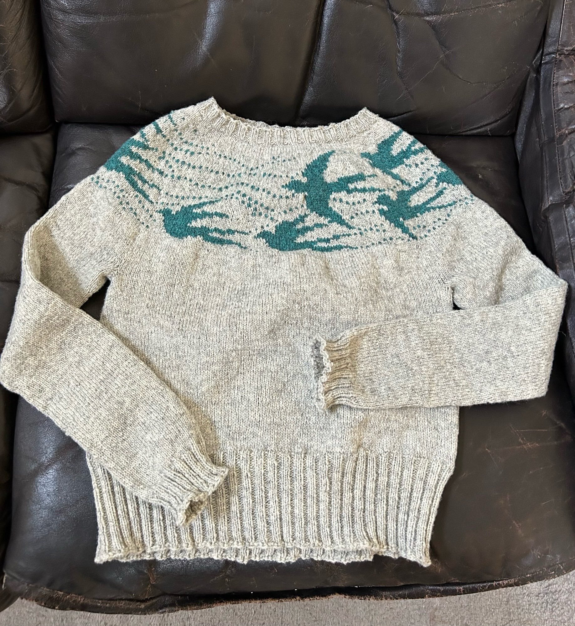 handknit gray sweater with flying birds around
the yoke in dark teal