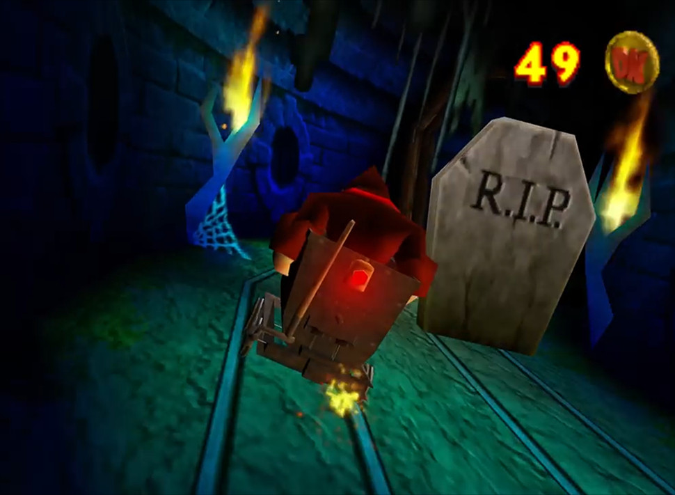 Donkey Kong rides a minecart in a haunted mineshaft and passes a tombstone marked with "R.I.P." Screenshot from Donkey Kong 64.