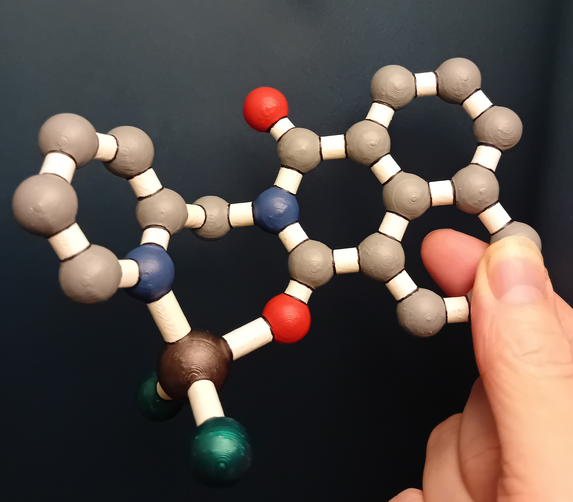 A 3d printed and hand painted molecular model - the molecule is a chelating 1,8-naphthalimide complex painted in a cartoon style