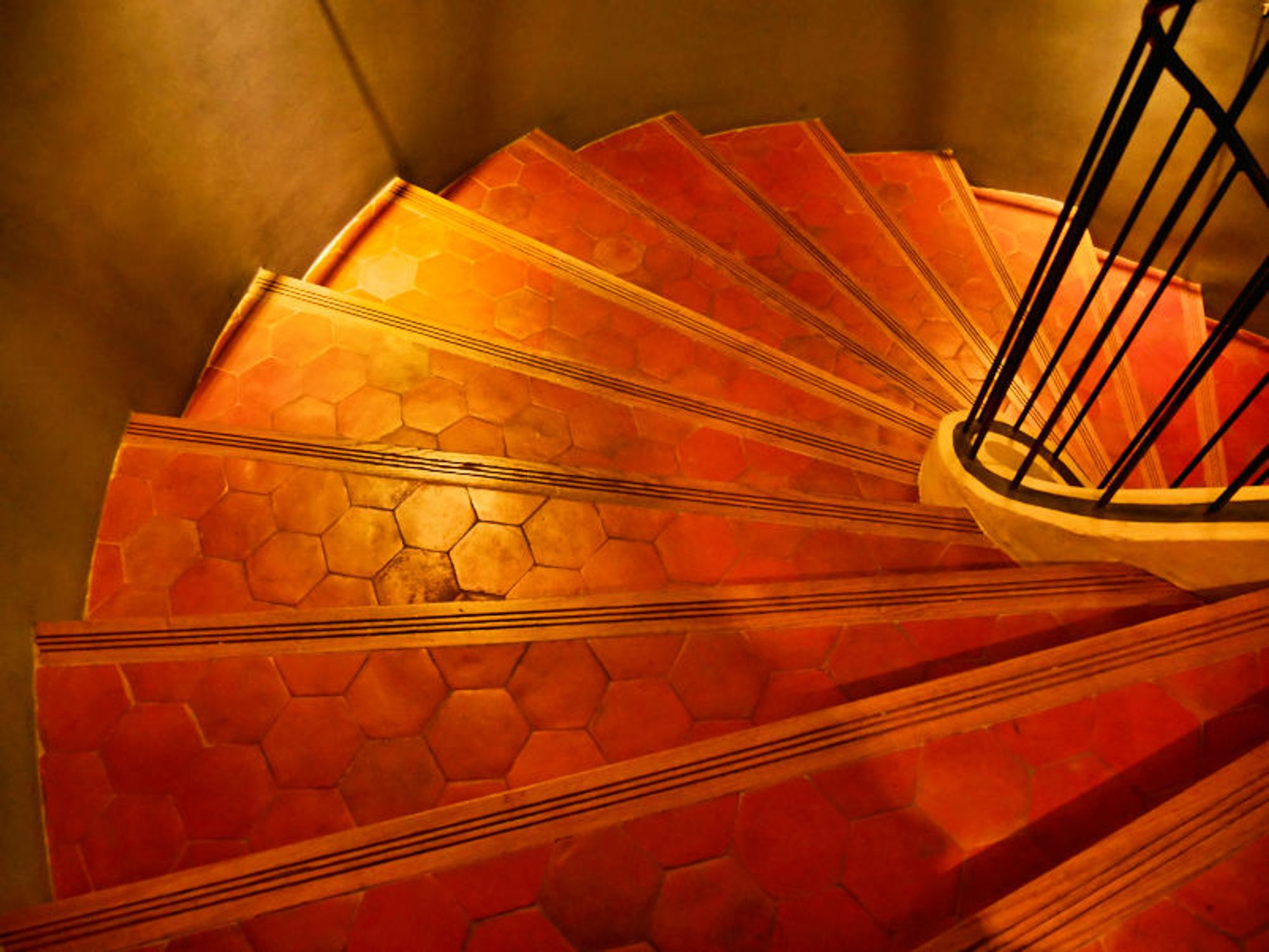 Steps in a spiral staircase glow in a dark stairwell in the Hôtel de Caumont which is a listed (historically and architecturally significant) hôtel particulier (a large mansion) in Aix that is now used to for art exhibitions. The Caumont was designed by architects Robert de Cotte (1656–1735) and Georges Vallon (1688-1767), and built from 1715 to 1742.