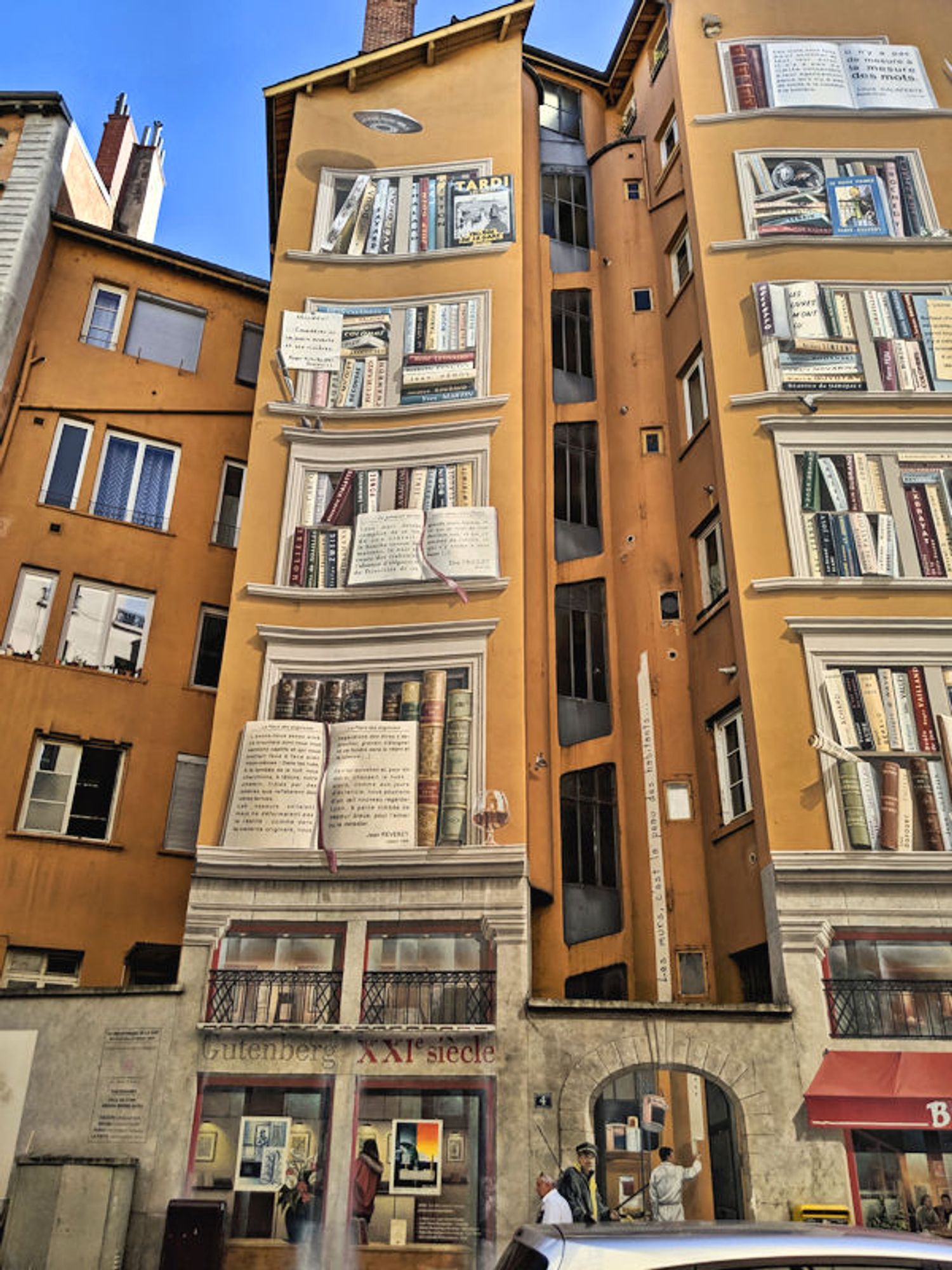 Wonderfully clever mural of books on shelves and books open to read painted on a building housing (of course) a bookstore in Lyon, France.