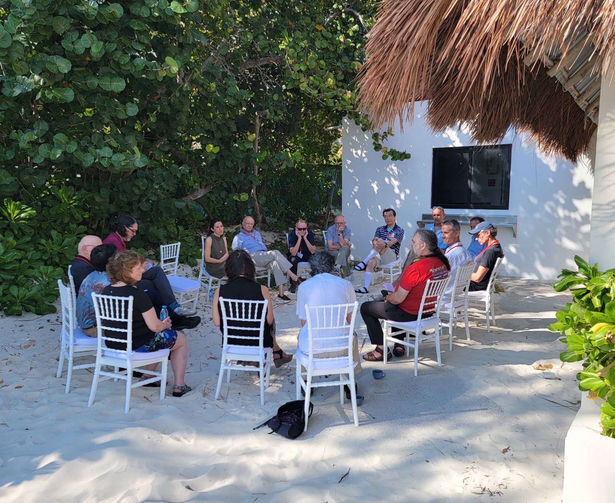 Winter school attendees engaging in a discussion on the beach