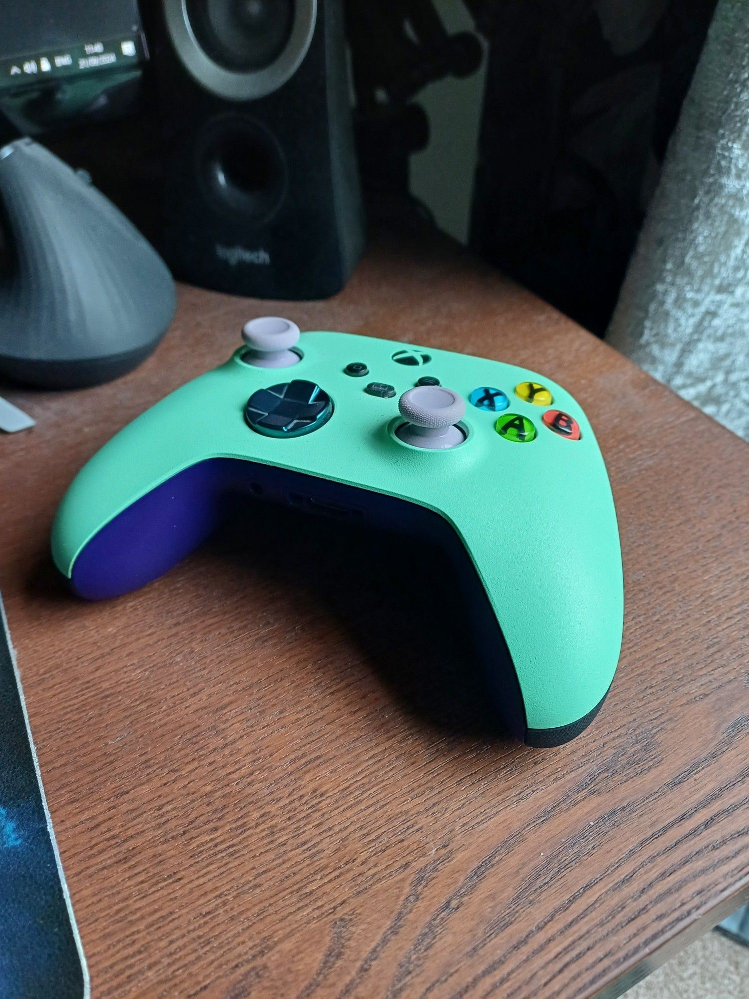 A custom-colour Xbox controller in mint green and dark purple.