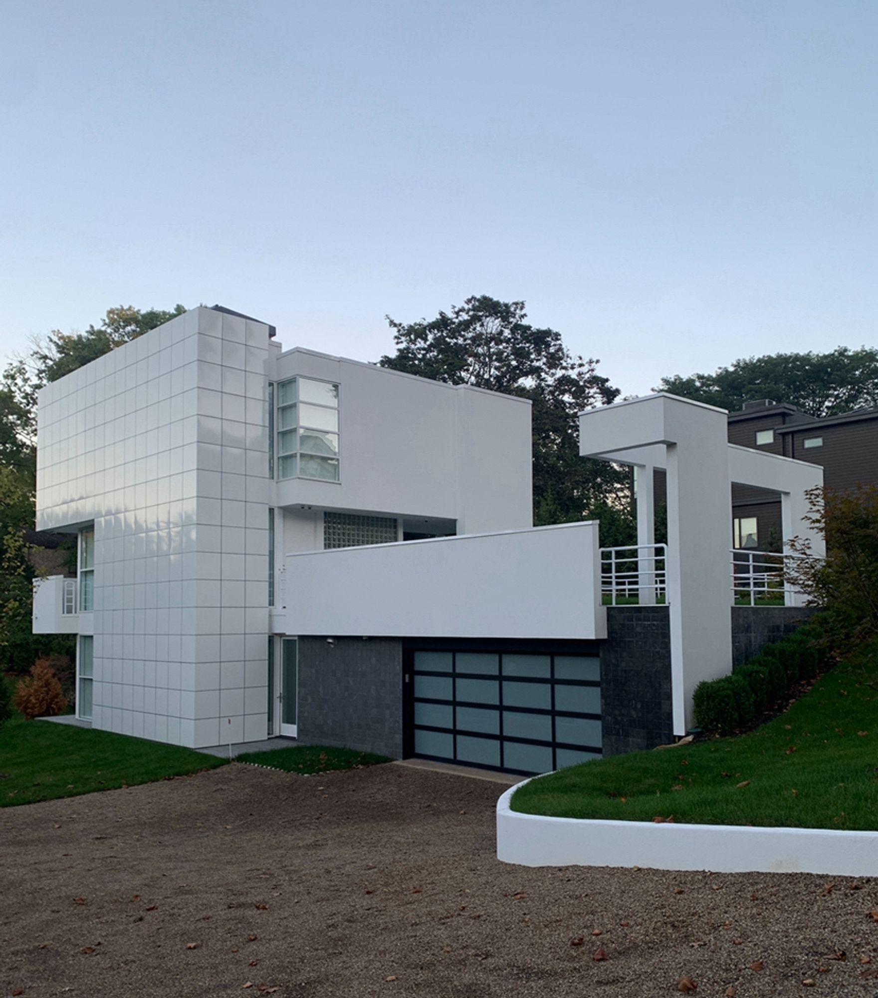 A white modern style house with an series of outdoor beams and structures, reminiscent of the redesigned home in the 1988 film Beetlejuice