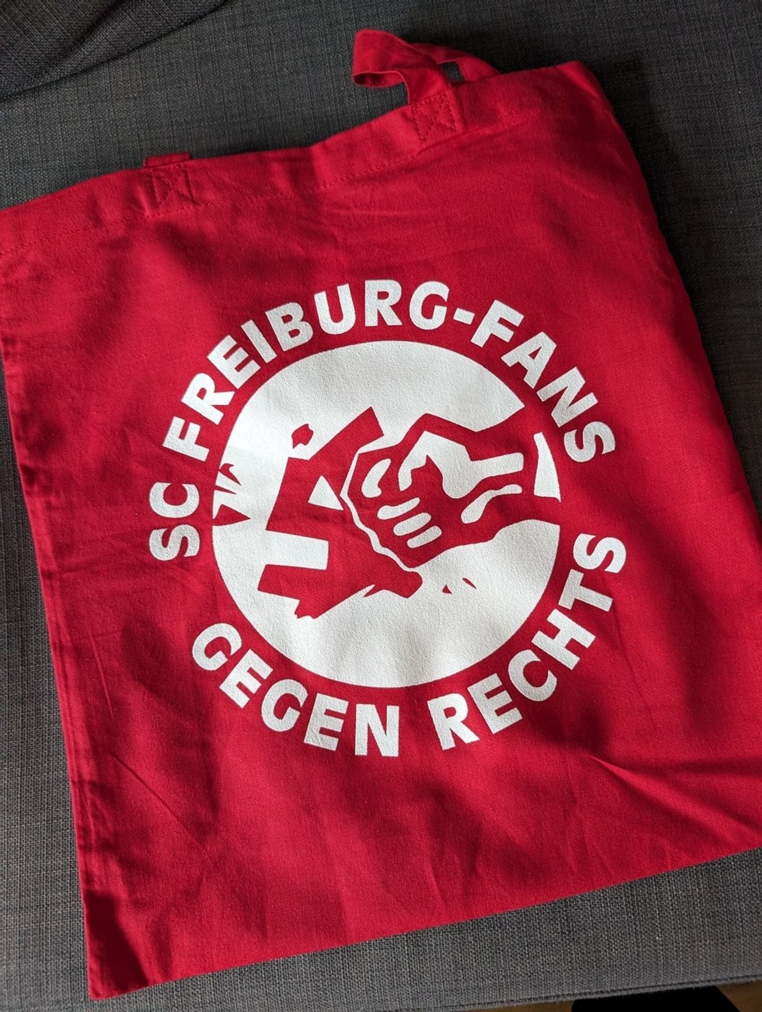 Eine rote Tragetasche mit der Aufschrift: "SC FREIBURG-FANS GEGEN RECHTS"