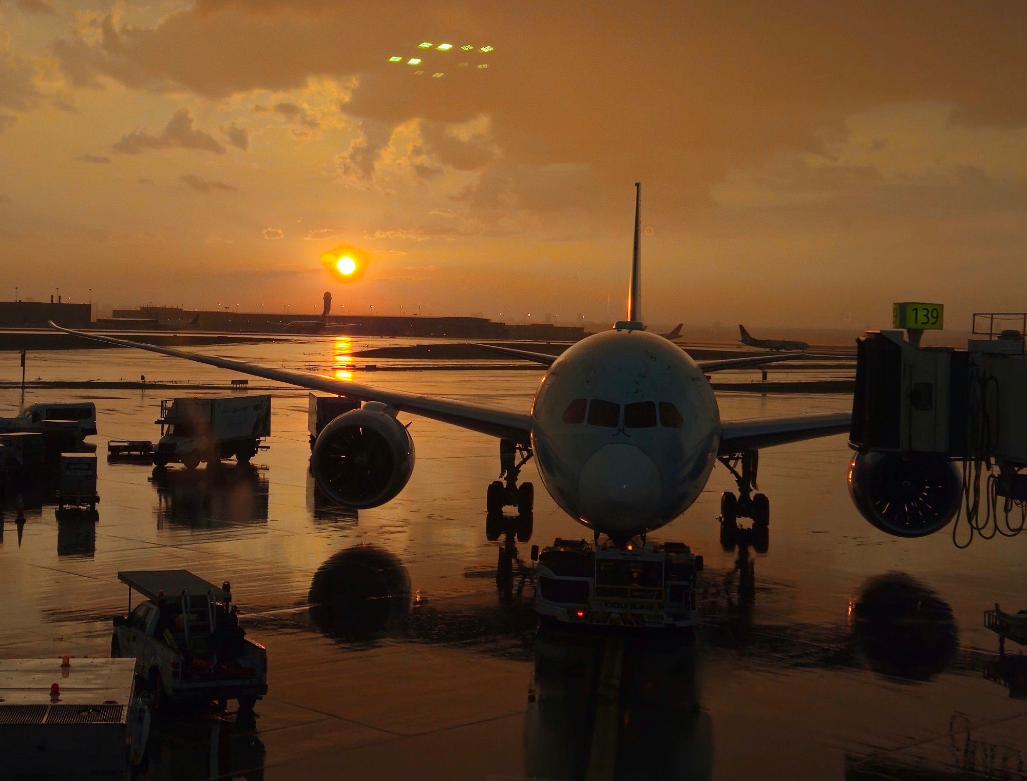 A photo of the sunset in Toronto Pearson International Airport (YYZ). The sun sets on the left side, and the cockpit of a plane and its wings is seen on the right side. Photo by Cole Pascua