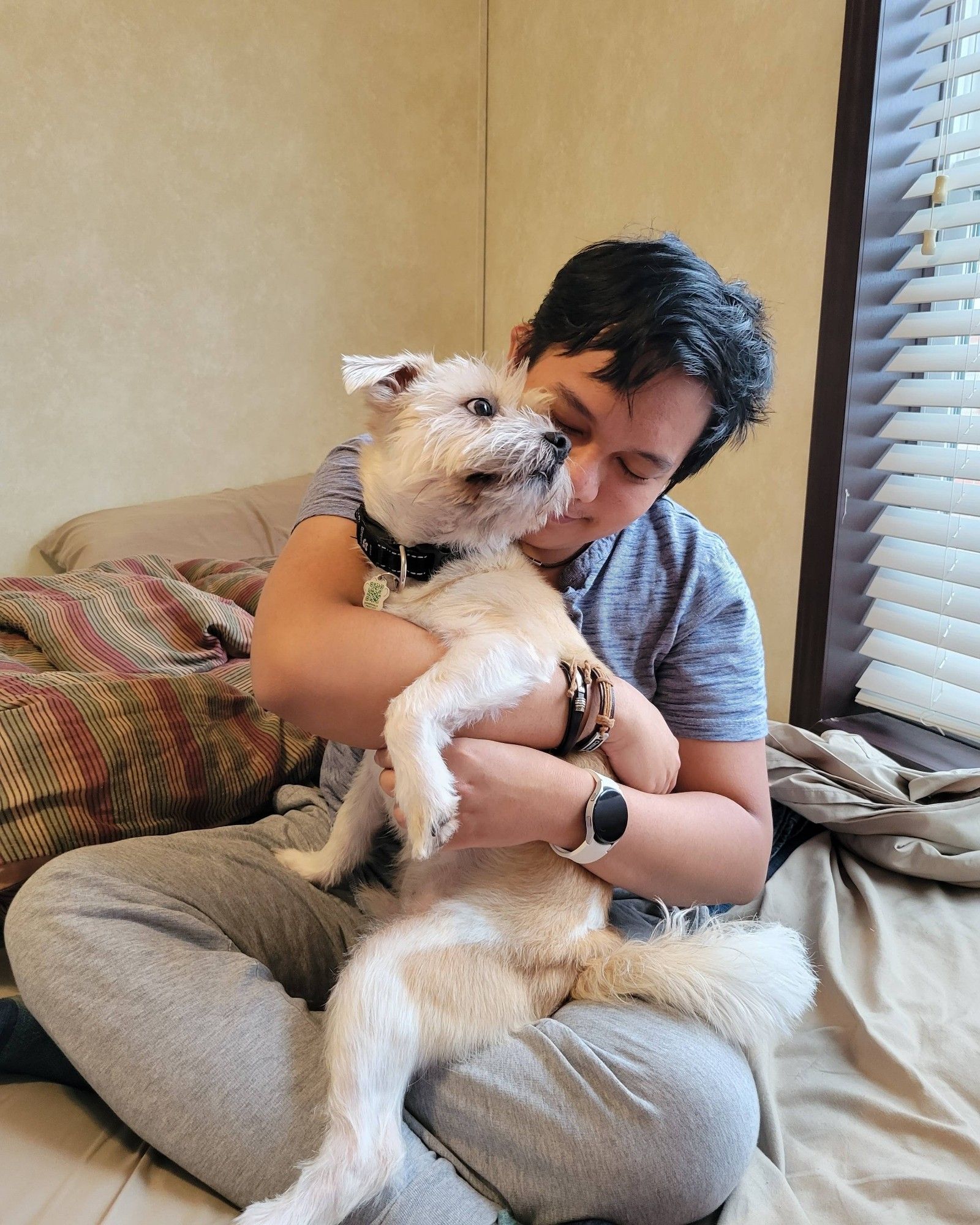 A photo of me (Cole Pascua) hugging my dog, Bailey, on top of my bed.