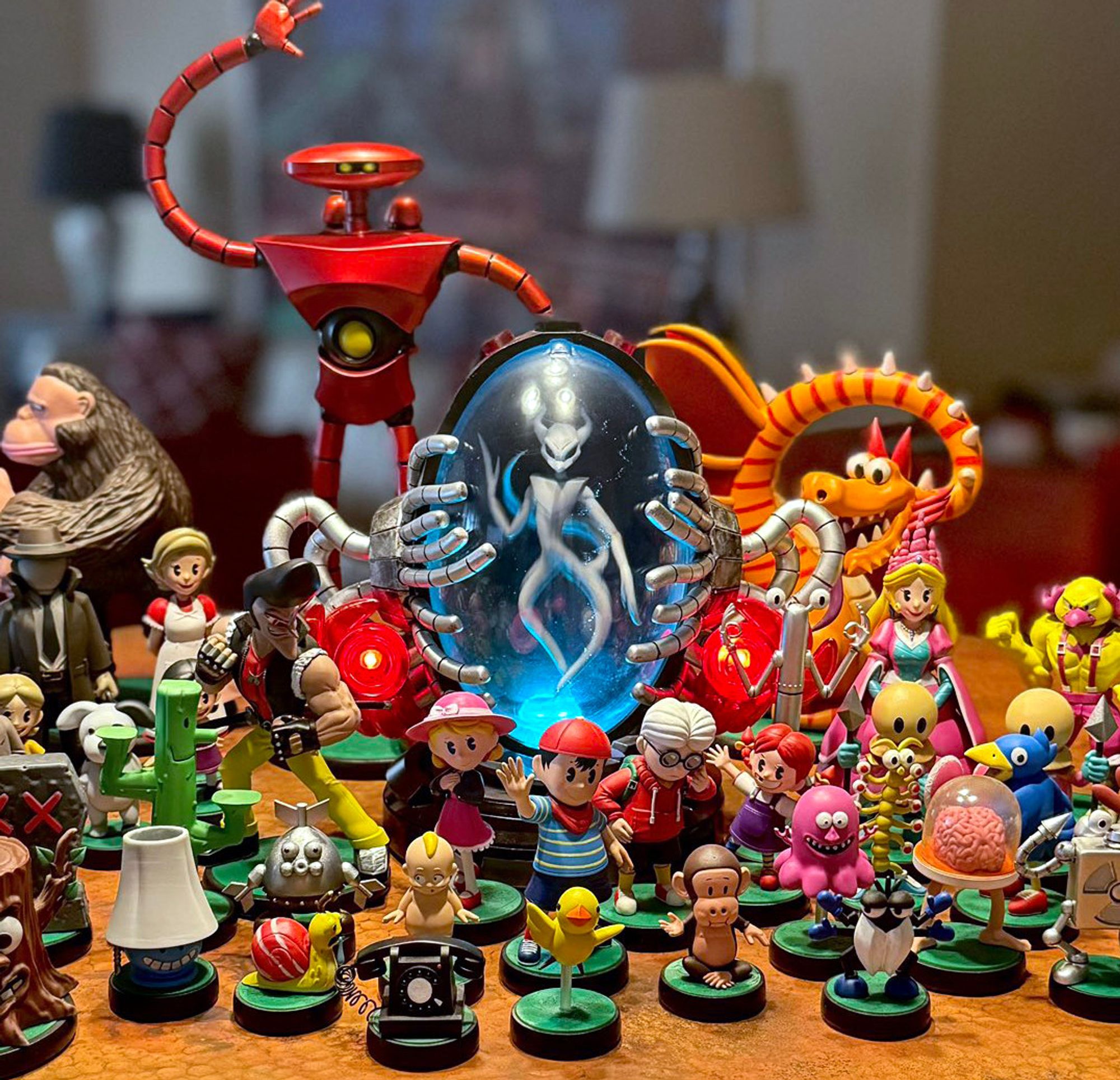 A spread of Cosmix's figures for MOTHER - Ninten, Ana, Lloyd, and Teddy in the center with the light up Gyiyg, EVE, and the dragon towering behind.