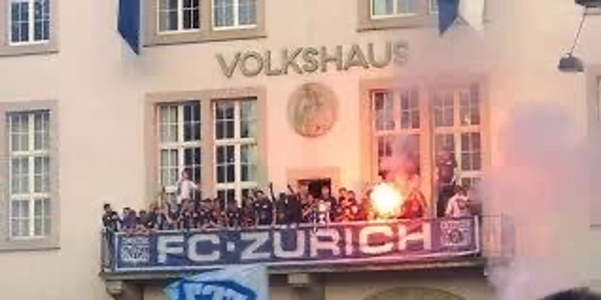 Die Meistermannschaft von 2018 auf dem Balkon vom Vollshaus in Zürich [ Meisterfeier ] auf dem Balkon werden Pyros gezündet  