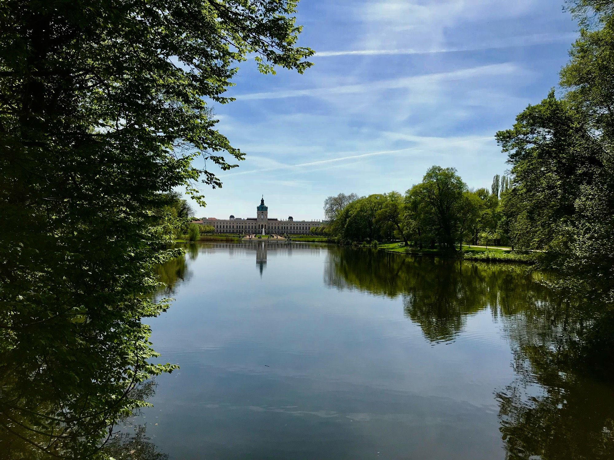 Ein kleiner See umrandet von Bäumen, im Hintergrund Schloss Charlottenburg