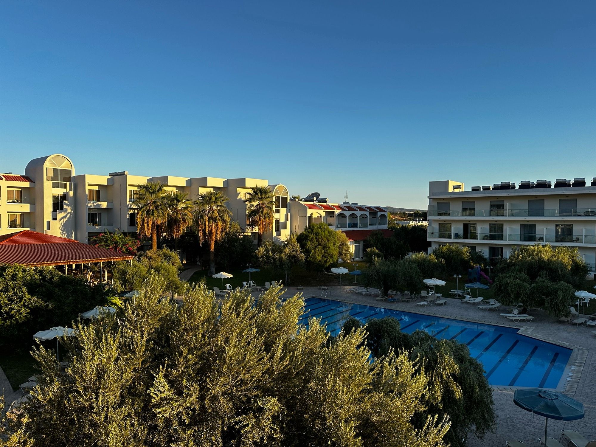 Blick auf eine Hotelanlage mit Pool bei blauen Himmel