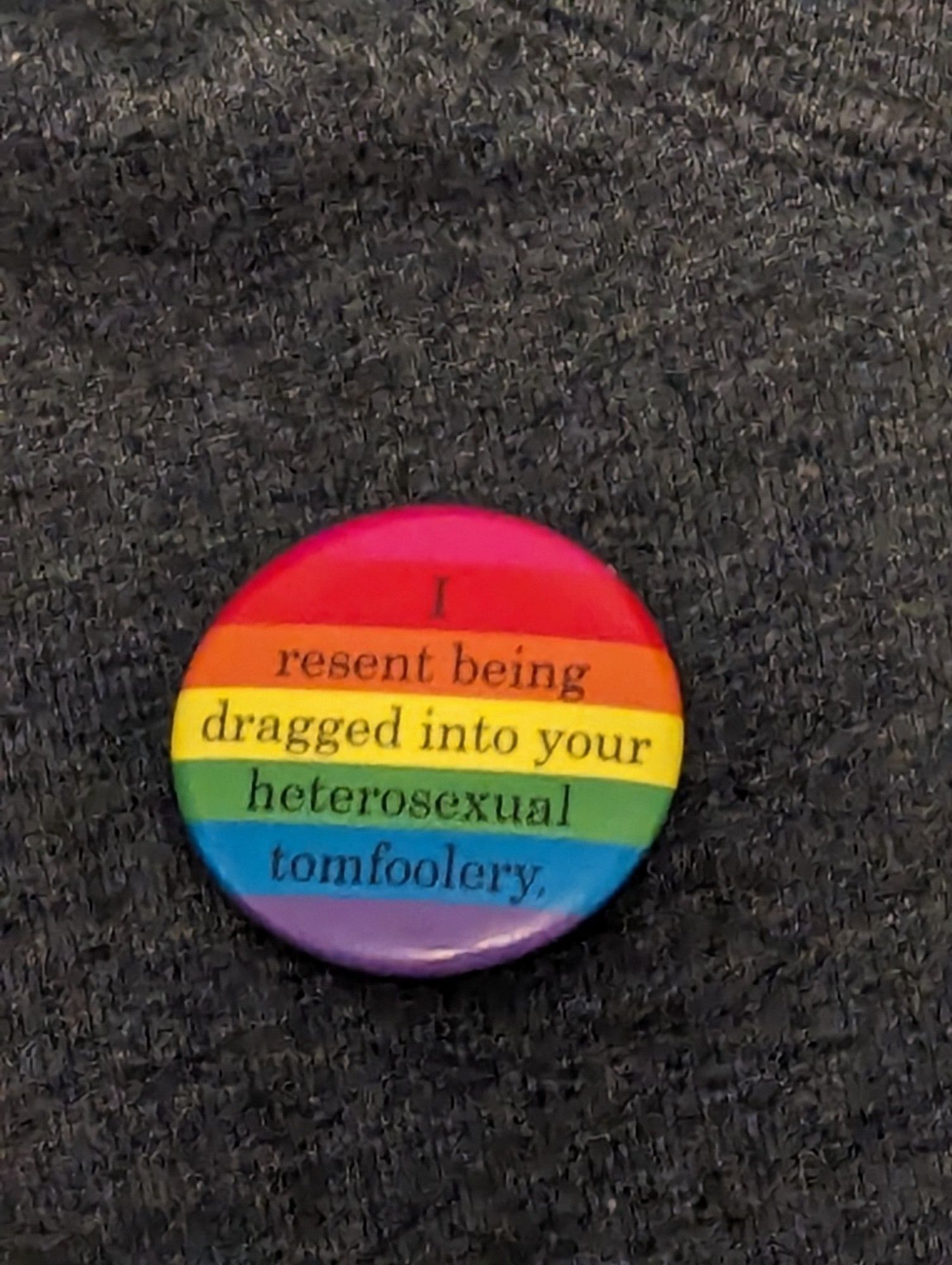 "I resent being dragged into your heterosexual tomfoolery" pin on a heather gray hoodie