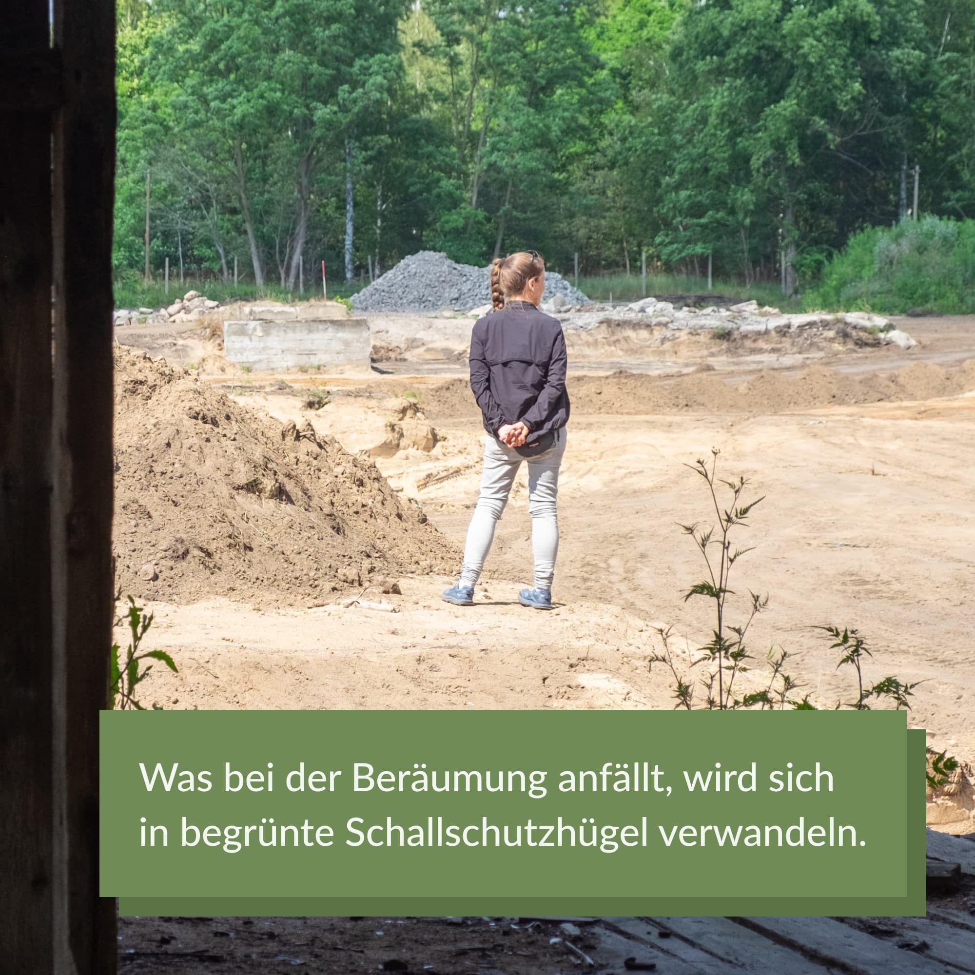 Eine Person von hinten. Sie hat die Hände auf dem Rücken und schaut über die Baustelle. Im Hintergrund sandige Flächen sowie Sand- und Betonbruchhügel.