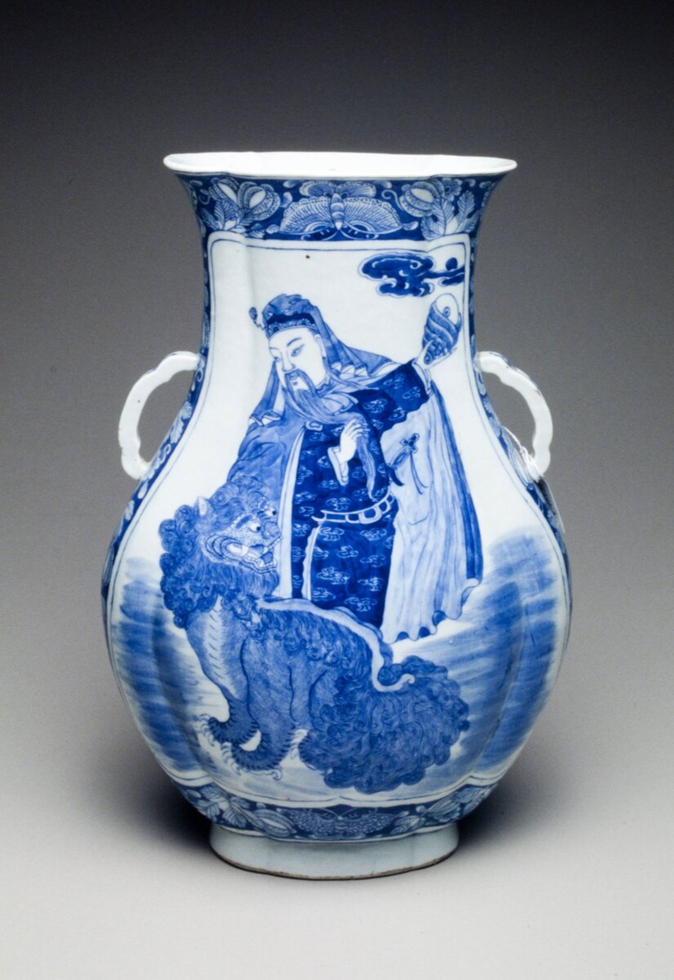 flattened oviform with lug handles; royal personage and Buddhistic lion motif in underglaze blue
This Chinese style vase, made for the Western market, is decorated with a Chinese royal personage and a Buddhist lion.