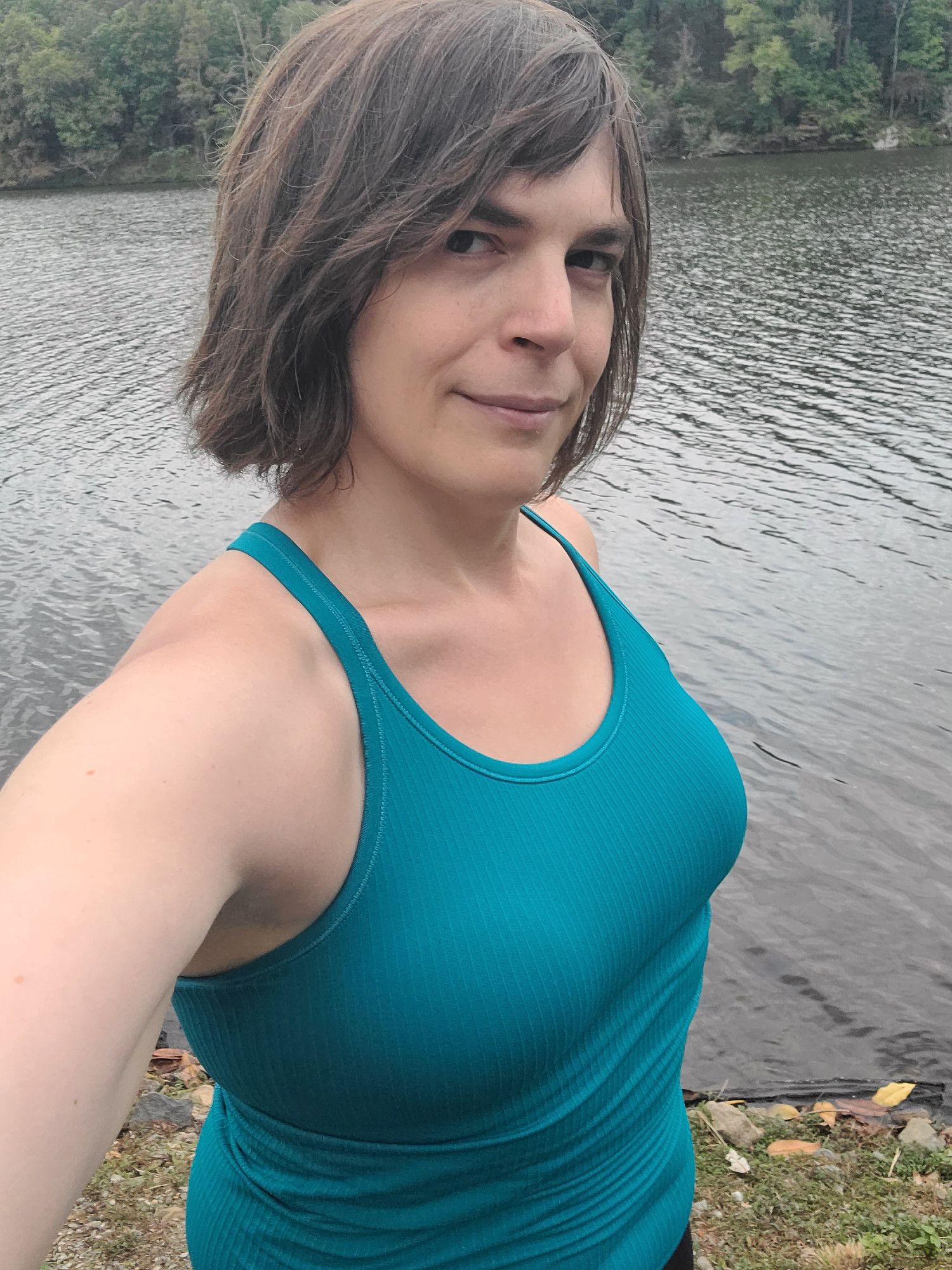 Well, it's Garrett in that teal workout tank that makes her tits look amazing, standing in front of a windswept lake with windswept hair and a little grin. She's wearing yoga pants and hopes she's safe enough doing so lol