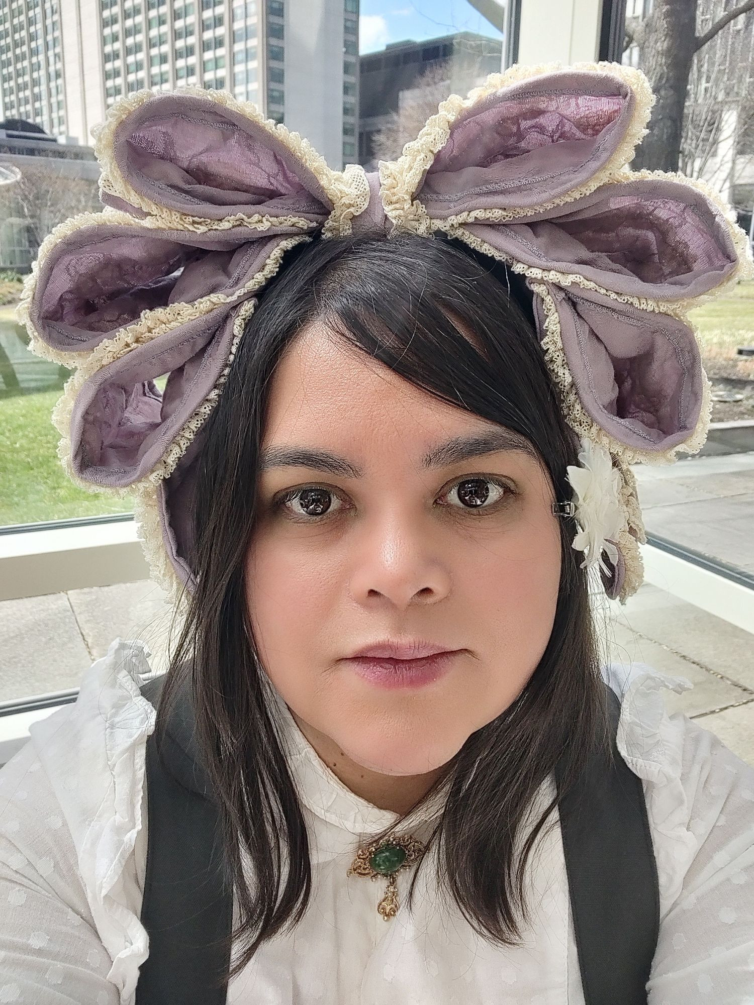 Me wearing a head dress by independent designer Hoshibako Works. It is a light purple with cream-colored ruffle trim, and has three loops, each stacked on top of the other.