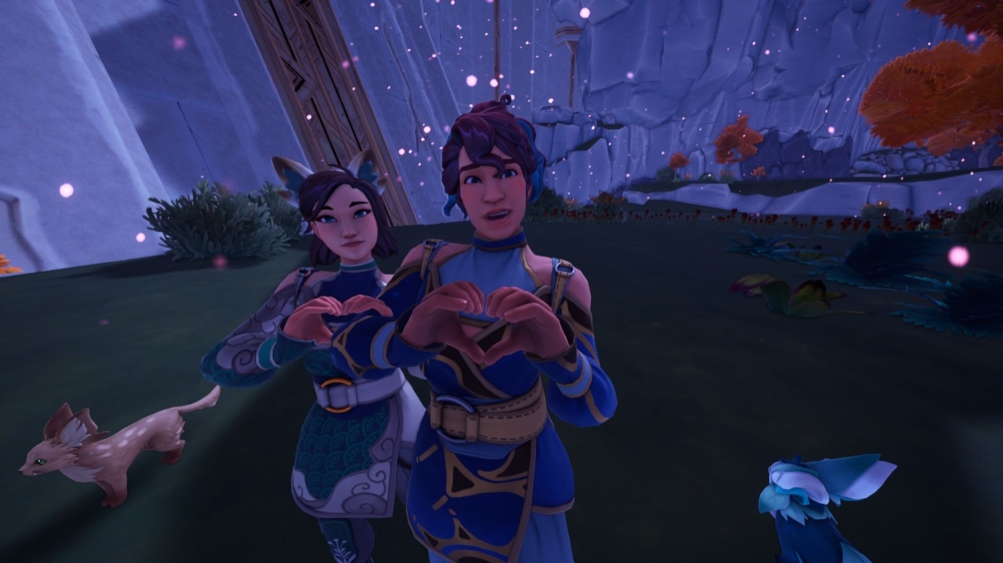 A screenshot from the MMORPG farming simulator called "Palia" showing who humans making hearts with their hands while standing in magical ruins. Next to them is a palcat (fictional feline) and a Flutter fox. Motes of purple light called "flow" are around them