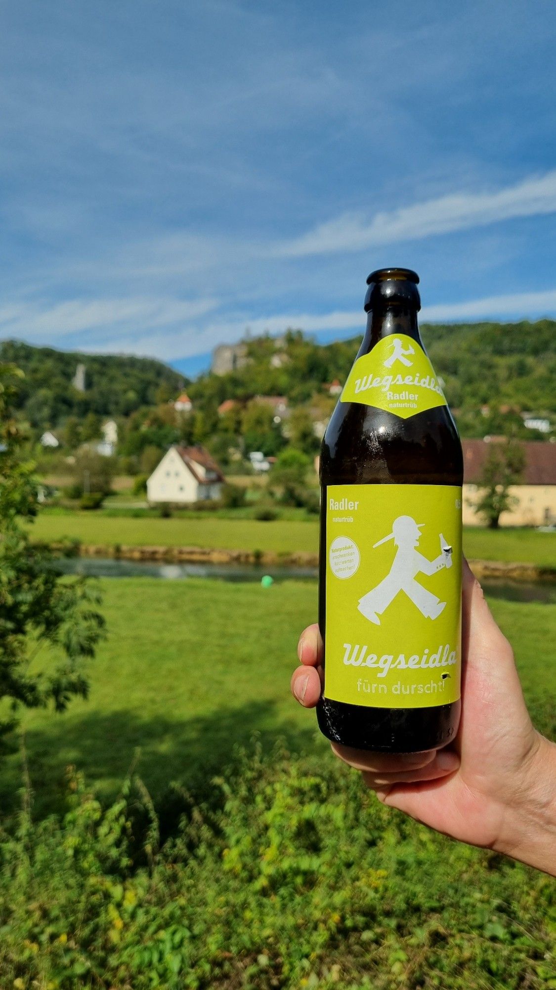 Bild von einer Bierflasche auf der Wegseidla (Wegbier) steht. Im Hintergrund sieht man Streitberg.