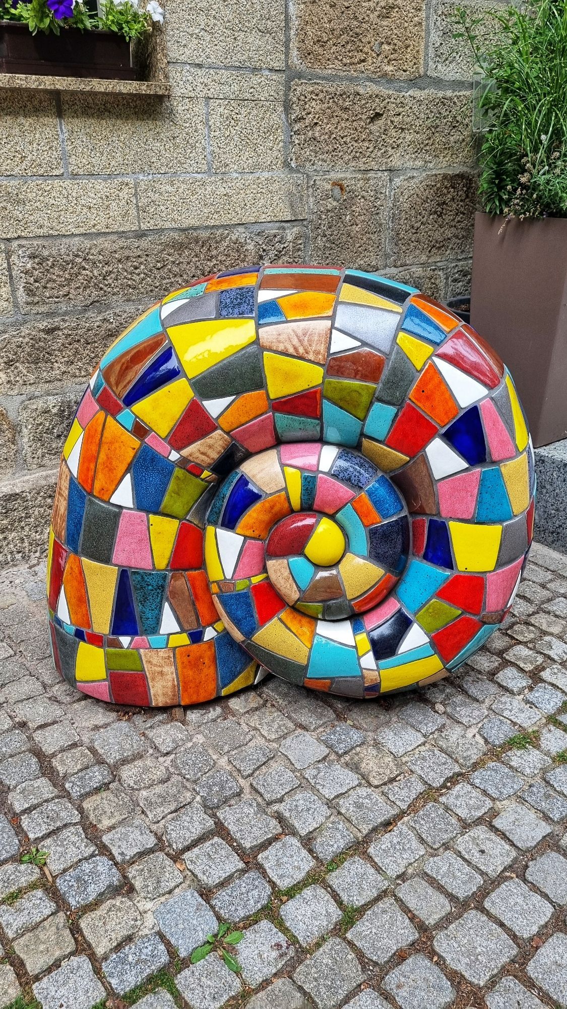 Große Schneckenhaus-Skulptur mit kunterbuntem Muster.