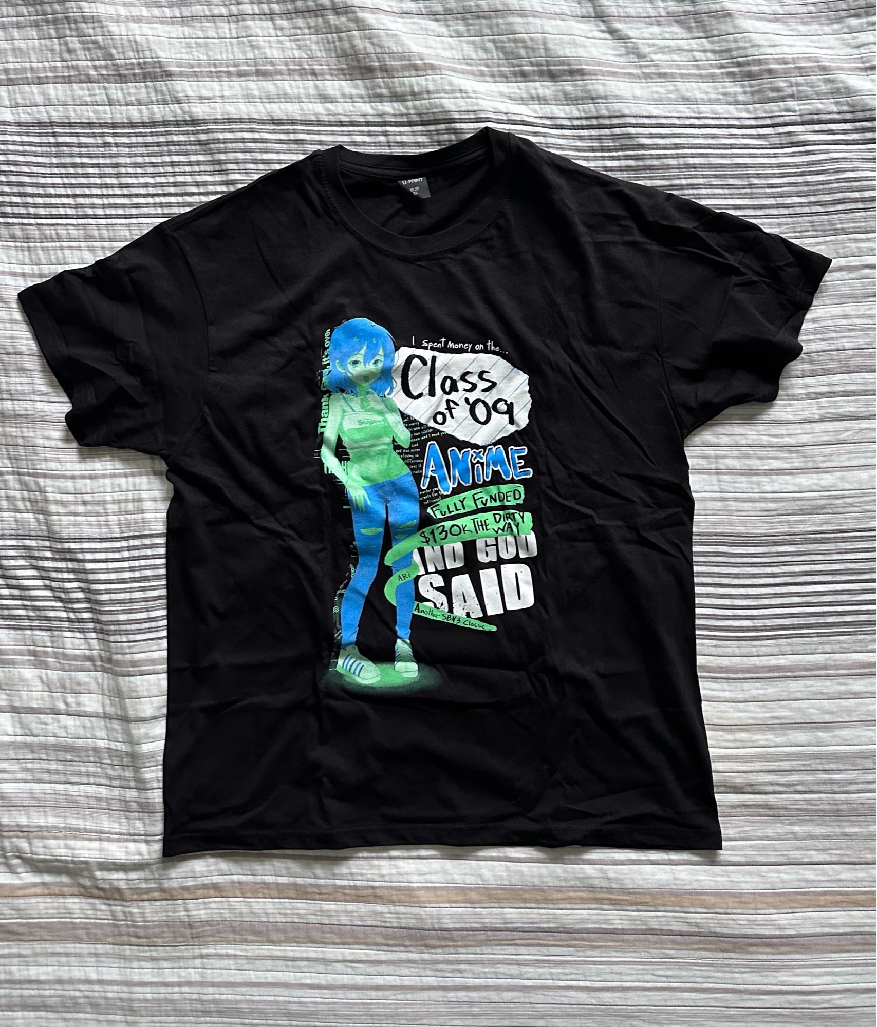 A black UxPrint T-Shirt with a picture of Ari from the video game Class of ‘09 with the words: “I spent money on the… Class of ‘09 Anime”, “Fully Funded”, “$130k the dirty way”, “Ari”, “And God Said”, “Another SBN3 Classic”.