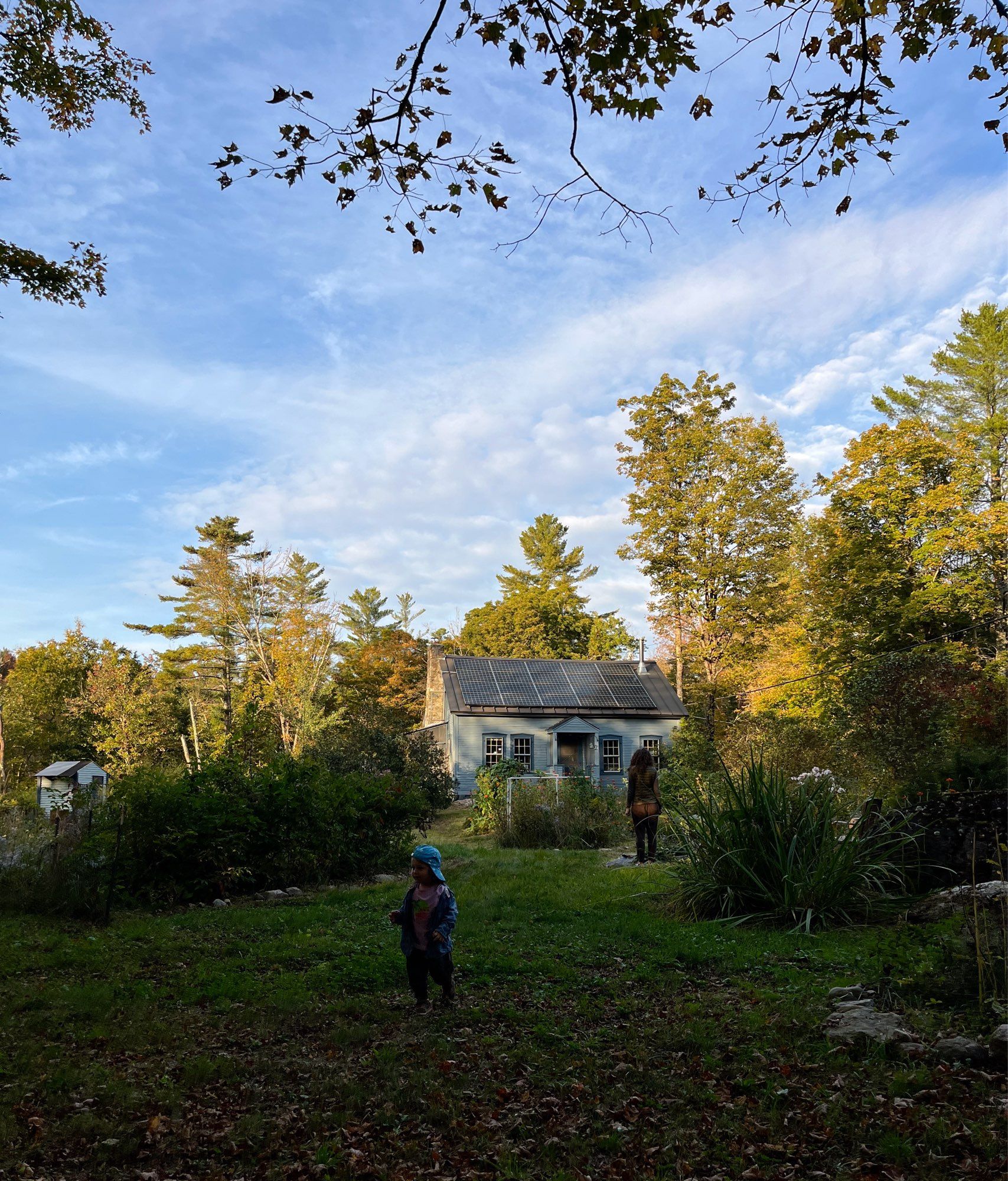 Toddler standing in a shaded garden in front of his grand uncle’s house