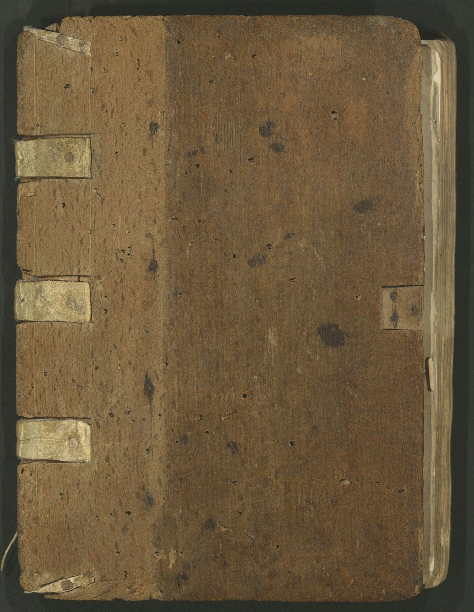 Front cover: wooden boards with leather spine covering and clasp removed, revealing original tawed sewing supports nailed in