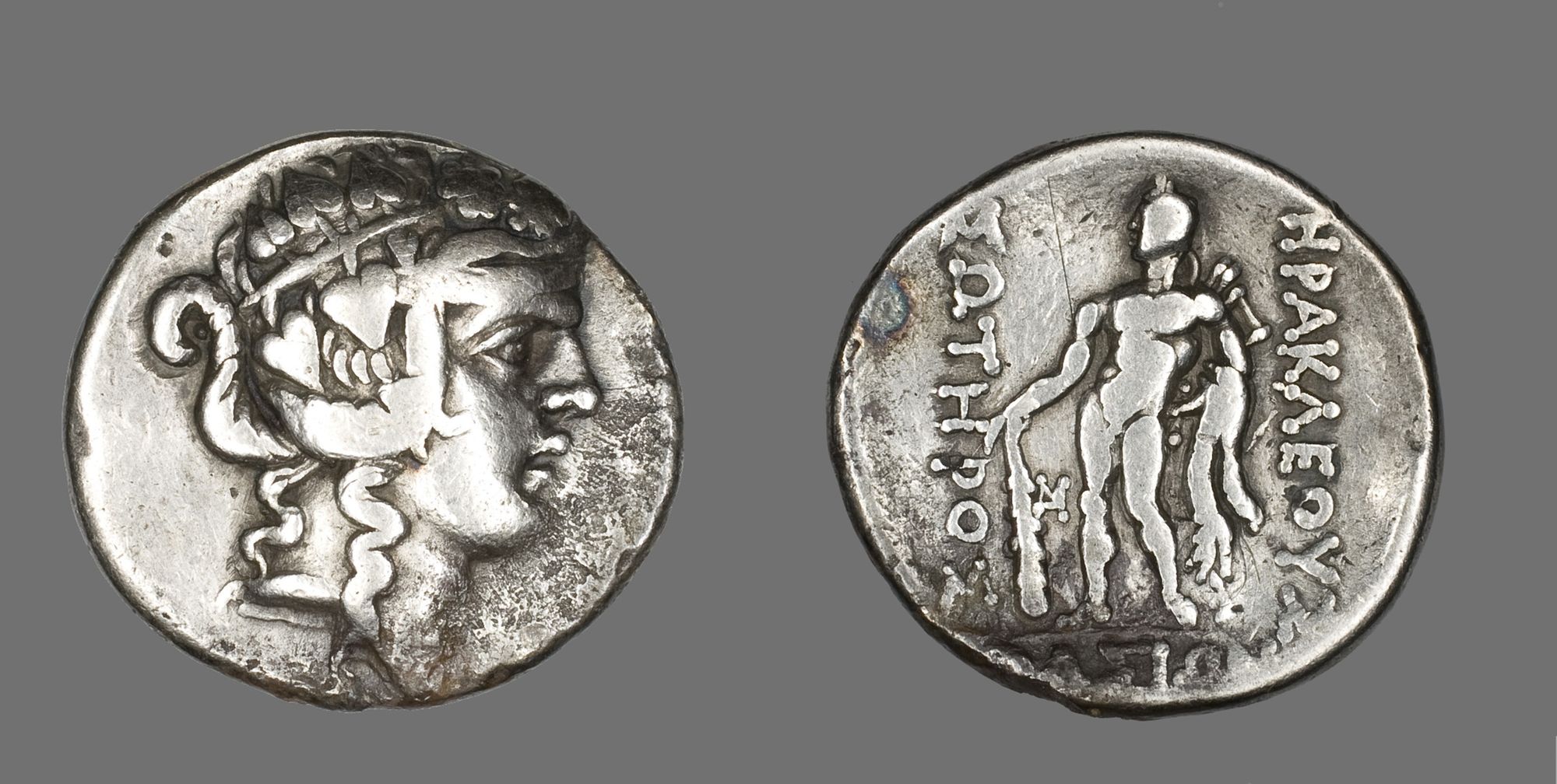 The front of this coin depicts the god Dionysos wearing a crown of ivy leaves.
On the back the hero Herakles is depicted wearing his signature lion skin cloak and holding a club.

Gift of Mrs. William Nelson Pelouze