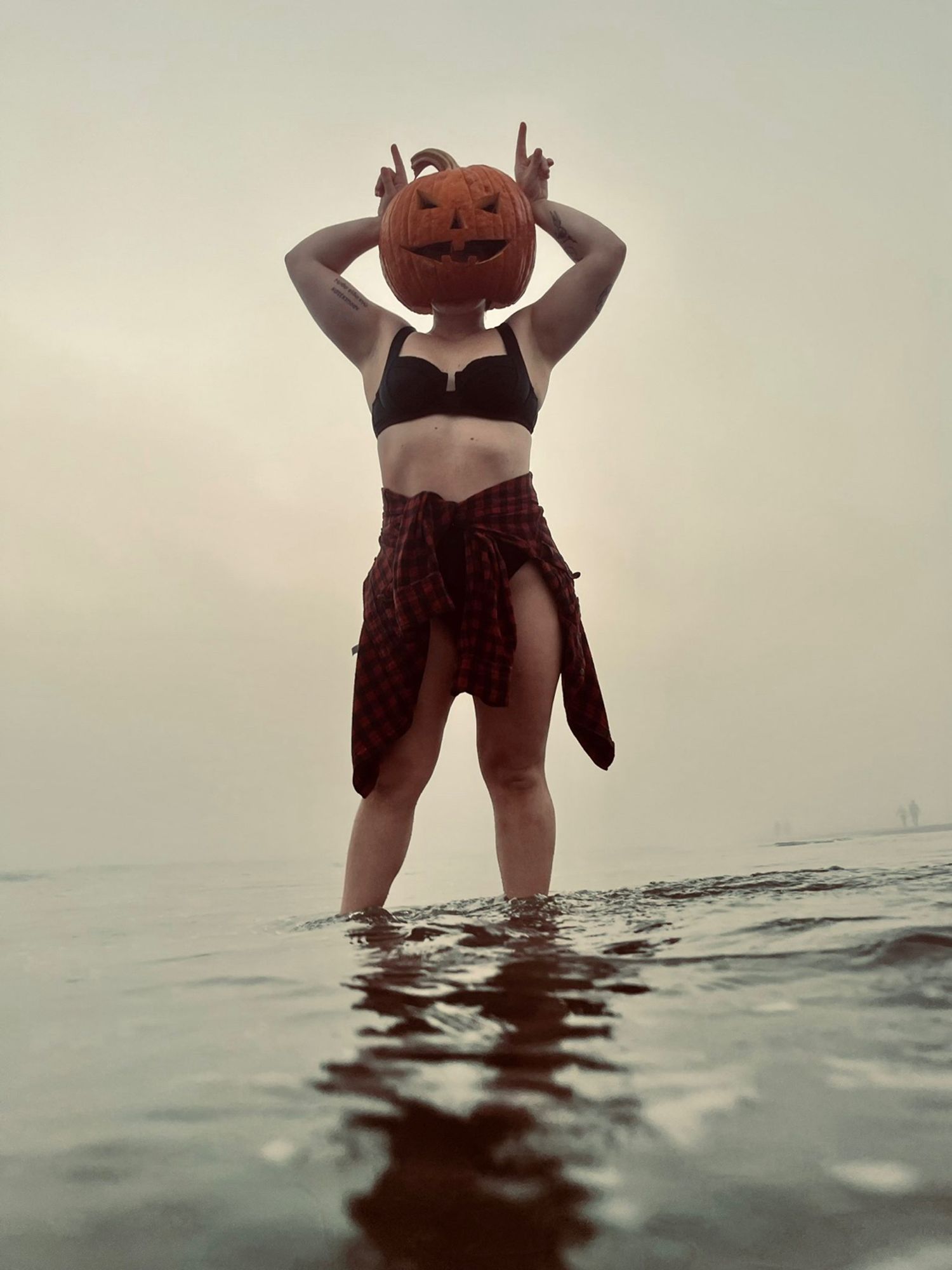 This is a photo of jes with a pumpkin on their head at the beach