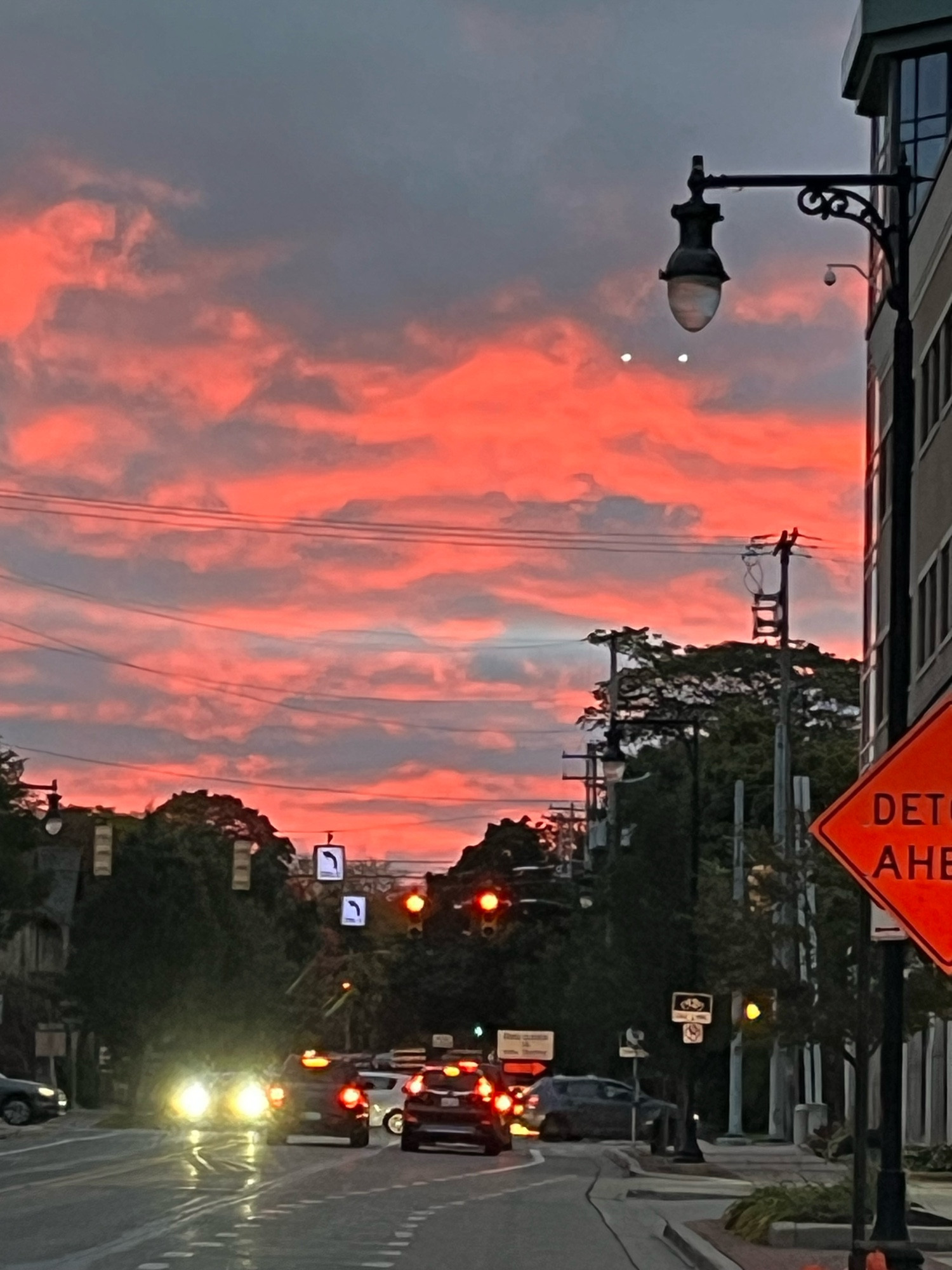 Morning sky with clouds lit orange-red by rising sun. Also misc cars and trees as I spotted the colors while dropping kids at schools 