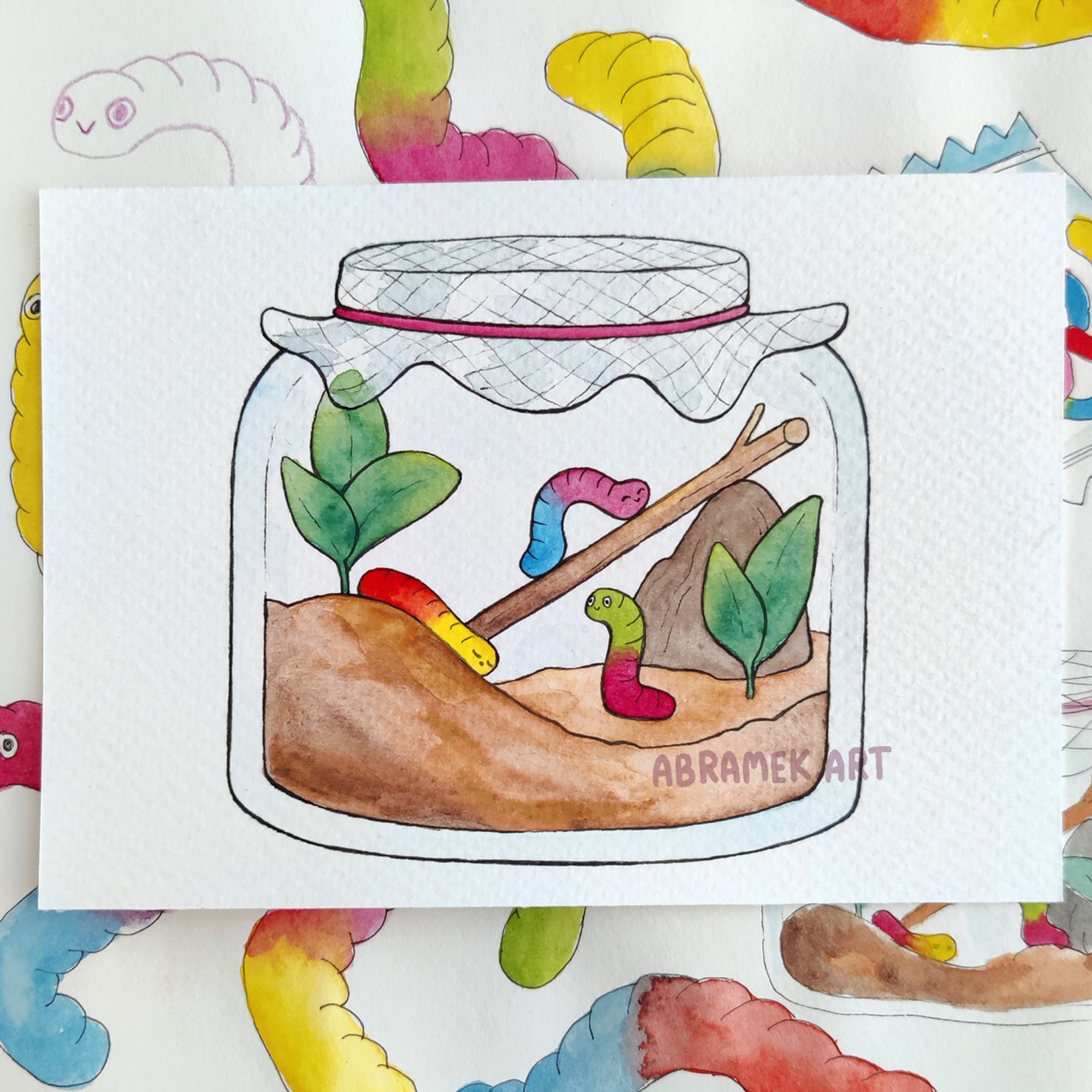 Watercolour and ink drawing of a jar. It is covered with a breathable cloth instead of a lid. Inside there is sand, a couple of plants, a rock, a stick, and three gummy worms playing.