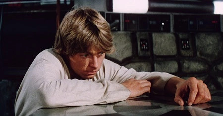 Luke Skywalker looking sadly down at a table