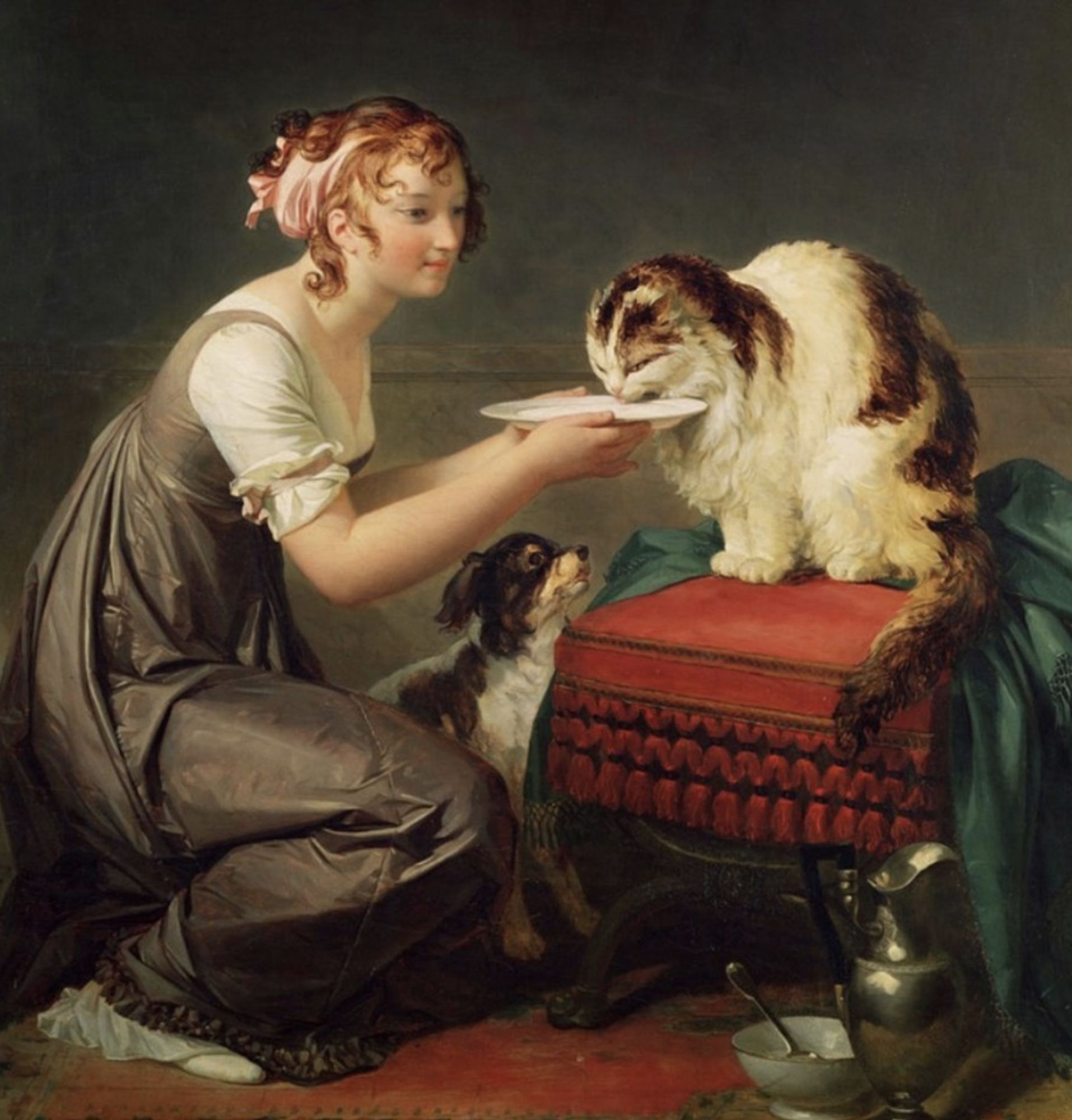 Oil painting of a pretty young white woman kneeling on a carpeted floor, holding a plate of food up for a fluffy tabby and white cat which is devouring whatever is on the plate. The woman has a faint, affectionate smile as she watches the cat eat. There is a small dog sitting up on the floor, looking eagerly at these lunch proceedings but he's apparently not invited.