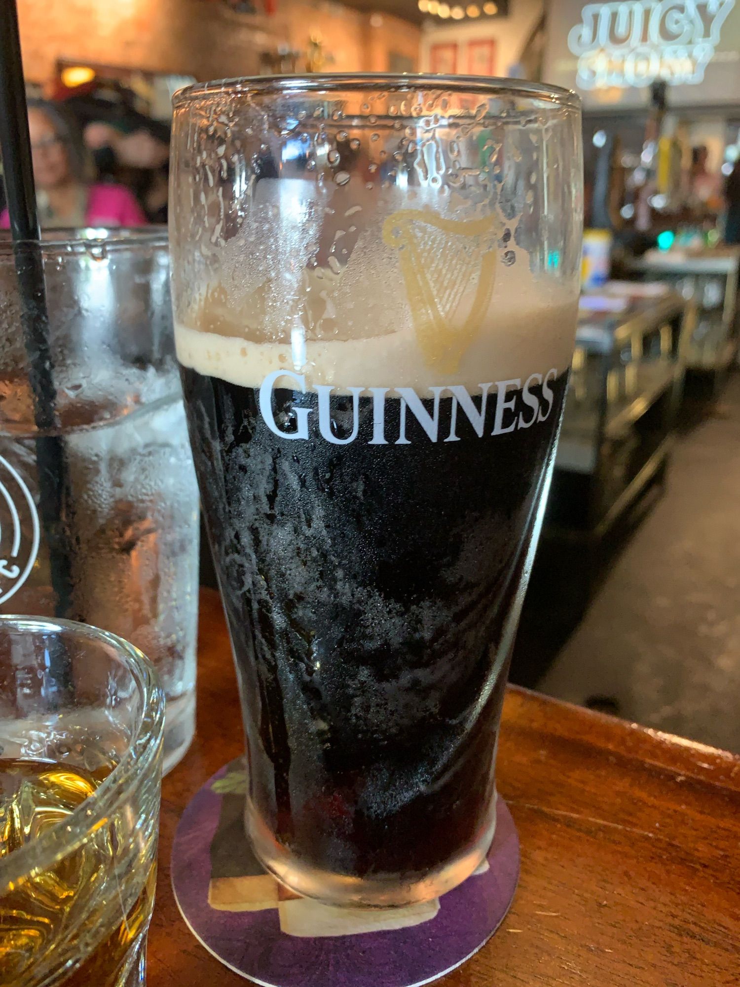 a glass of guinness where the line between the foam and the stout is just within the opening of the capital letter "G"