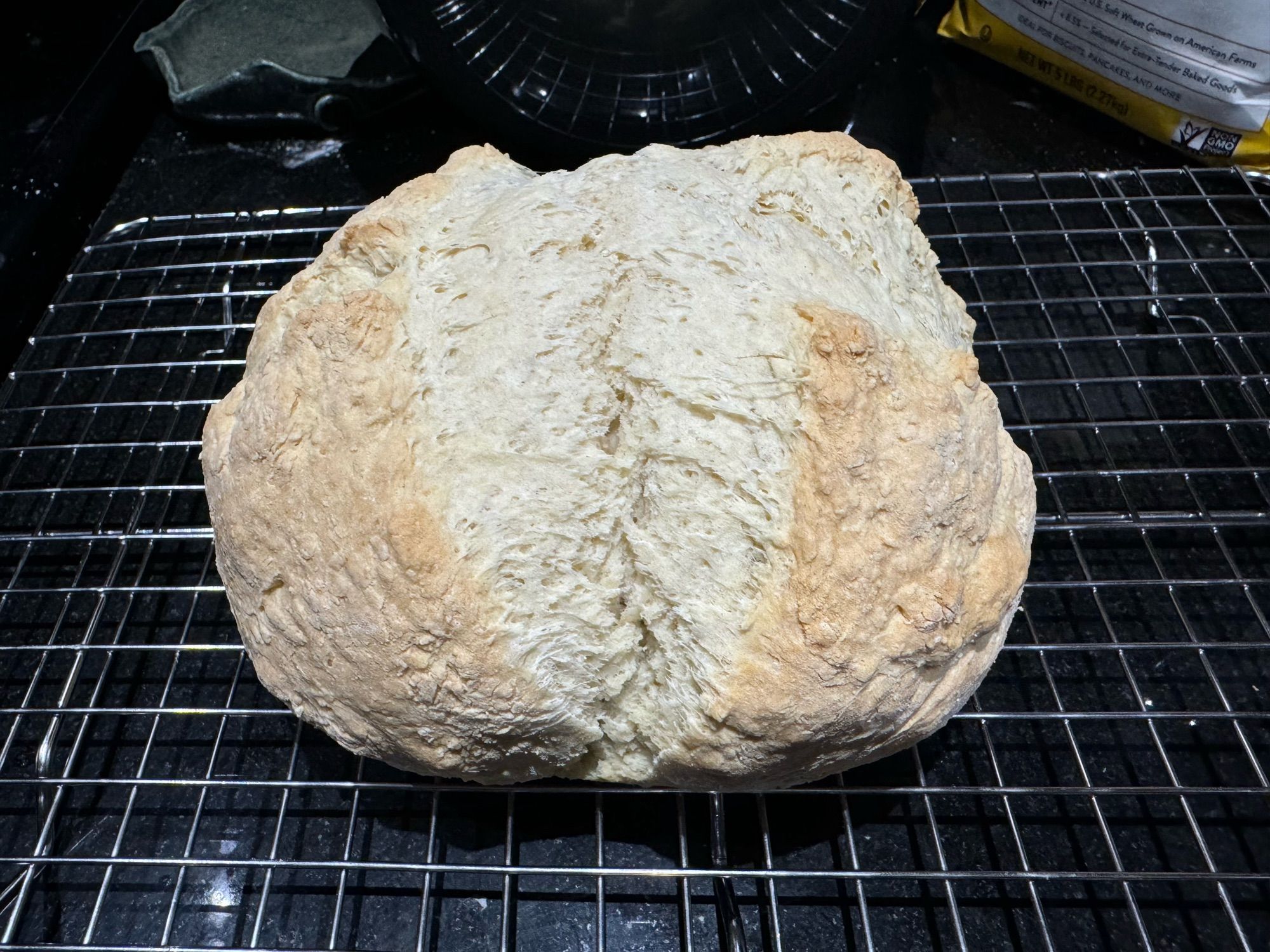 A loaf of Irish soda bread on a cooling rack.