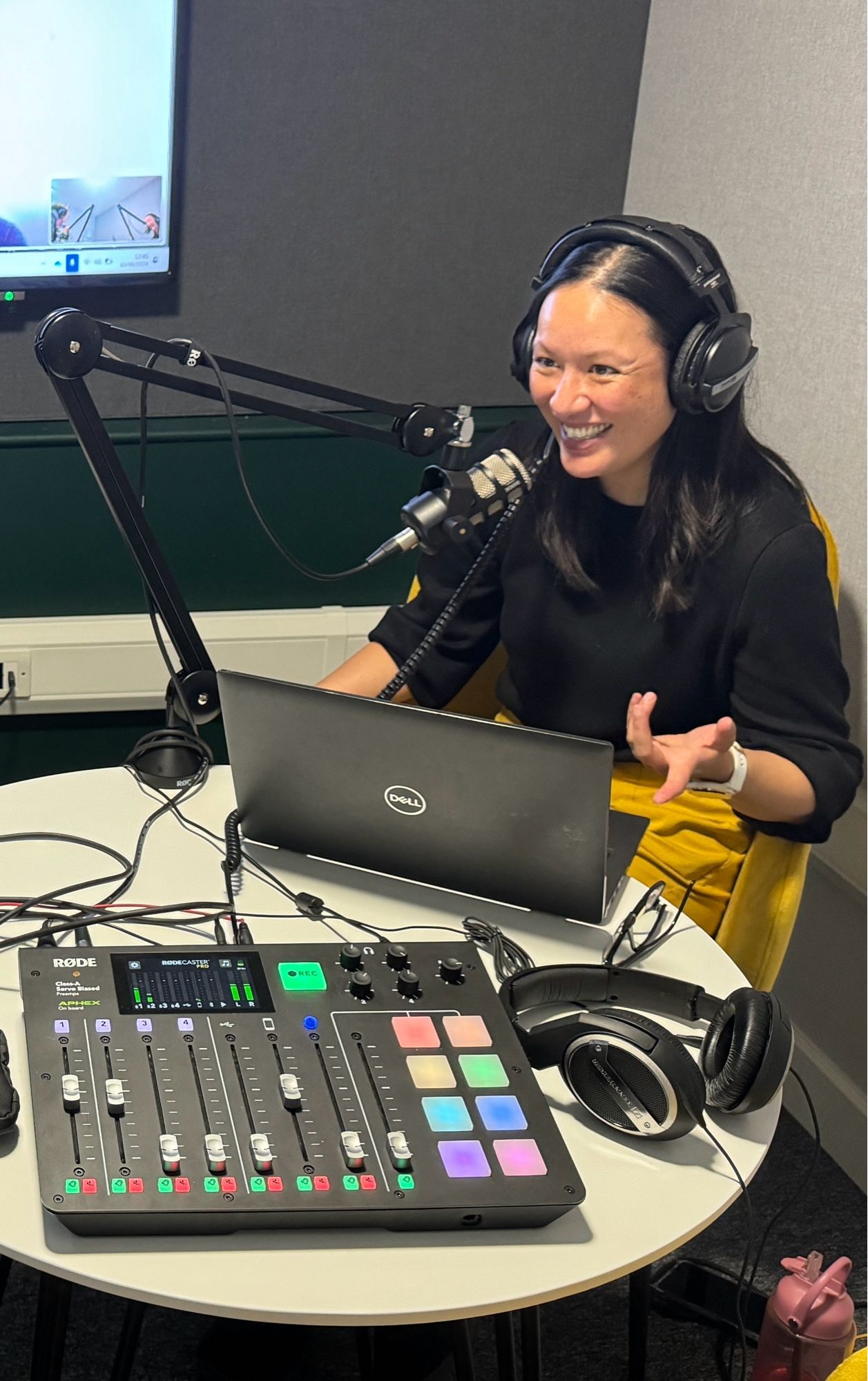 The host, Denise Voon smiling whilst interviewing in the recording studio.