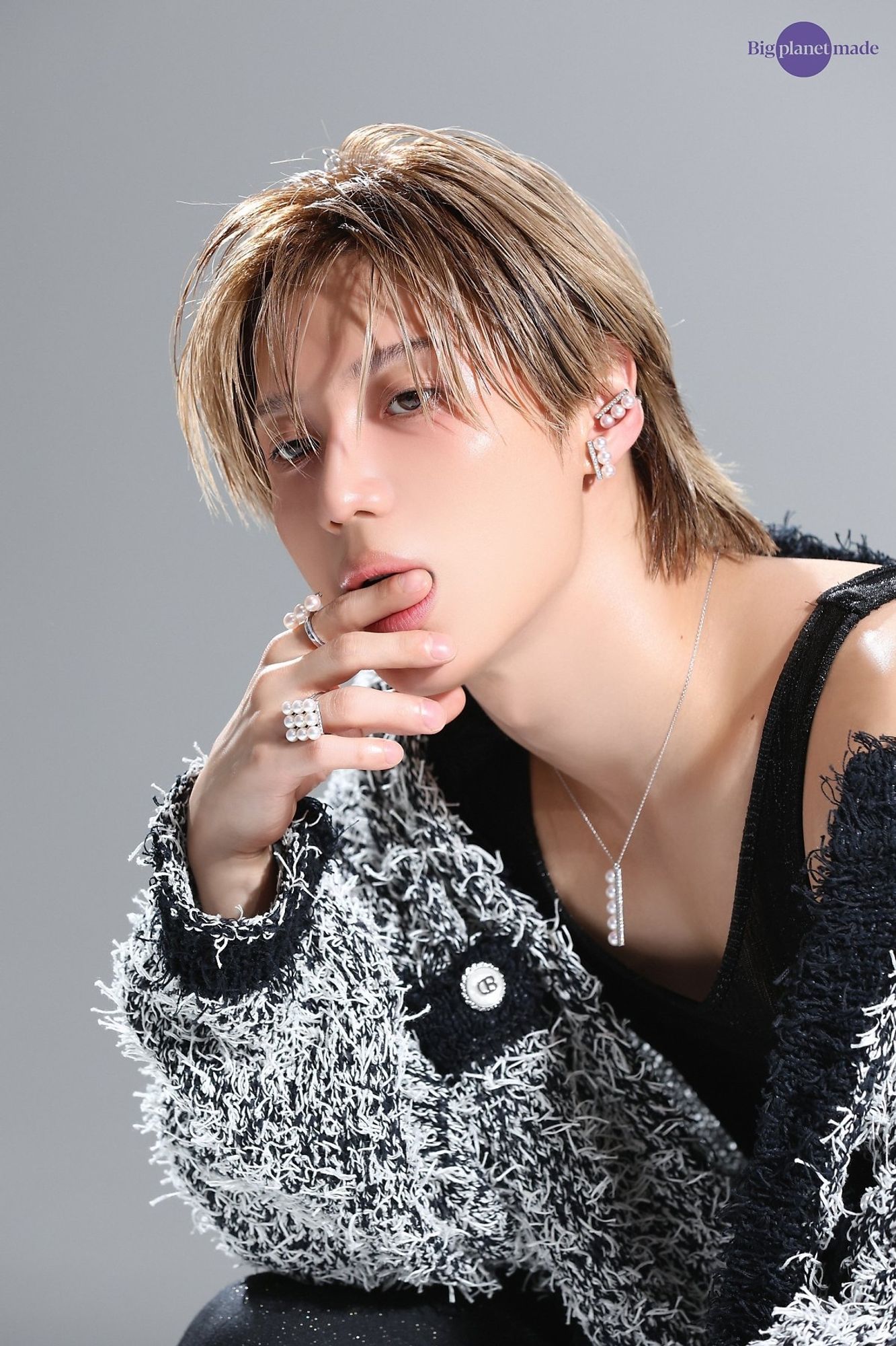 Elle photoshoot. SHINee Taemin wearing white fuzz fringe engulfing black base sweater that is casually sliding off his shoulder to reveal a black tank. Pearl jewelry including rings, pendant, and earrings. Staring through stylized blonde bangs. Gently biting finger like its a normal day.