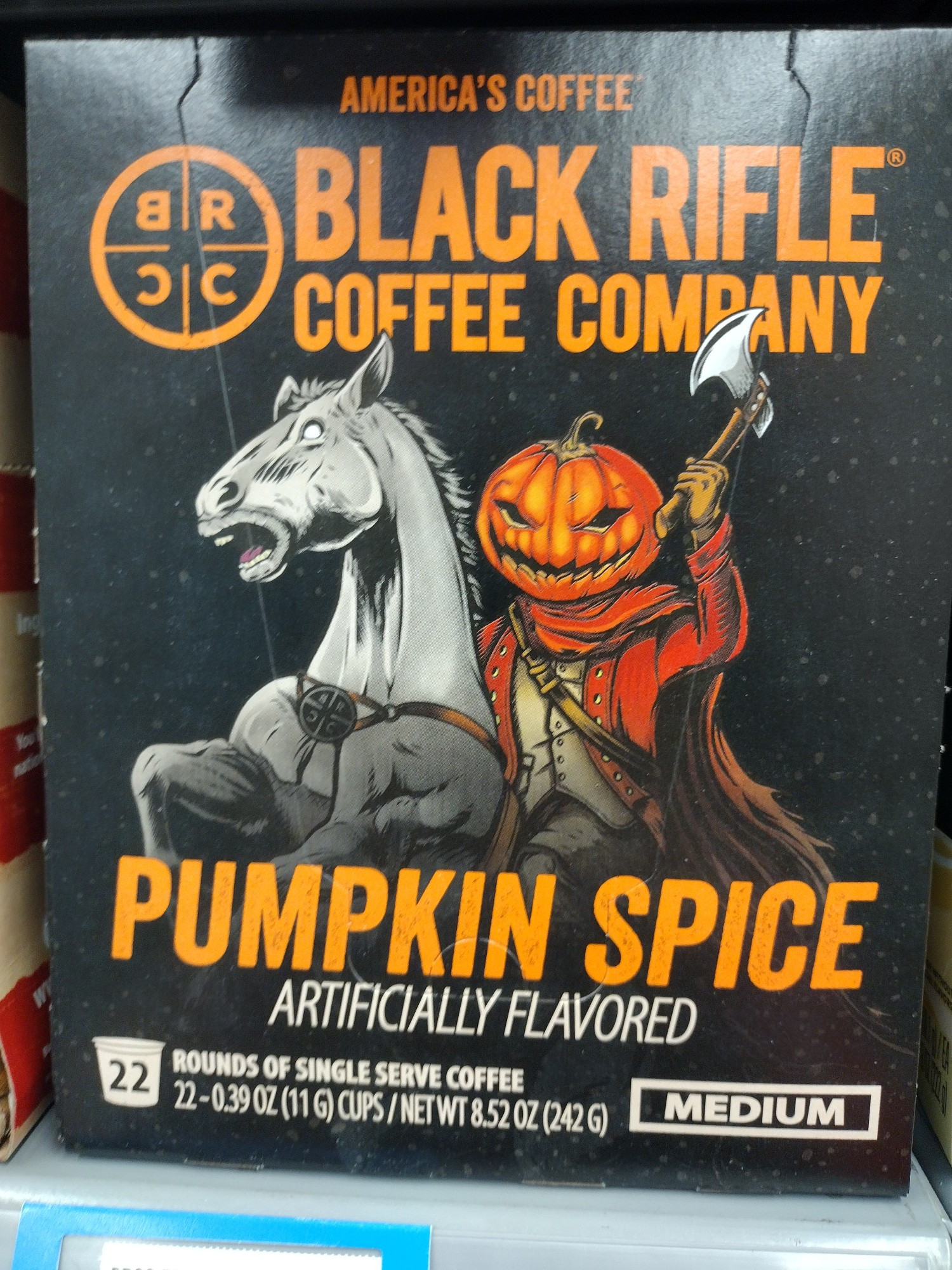 A photo of a box of Black Rifle Pumpkin Spice Coffee. The art on the box depicts the Headless Horseman wielding a hatchet while riding on a pale horse.