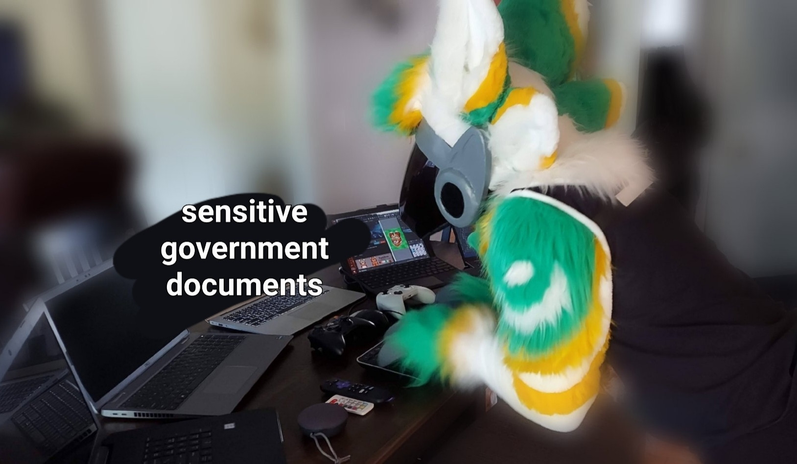 Protogen fursuit in front of a comical number of mismatched electronics with the label 'Sensitive Government Documents', implying he's hacking as a joke