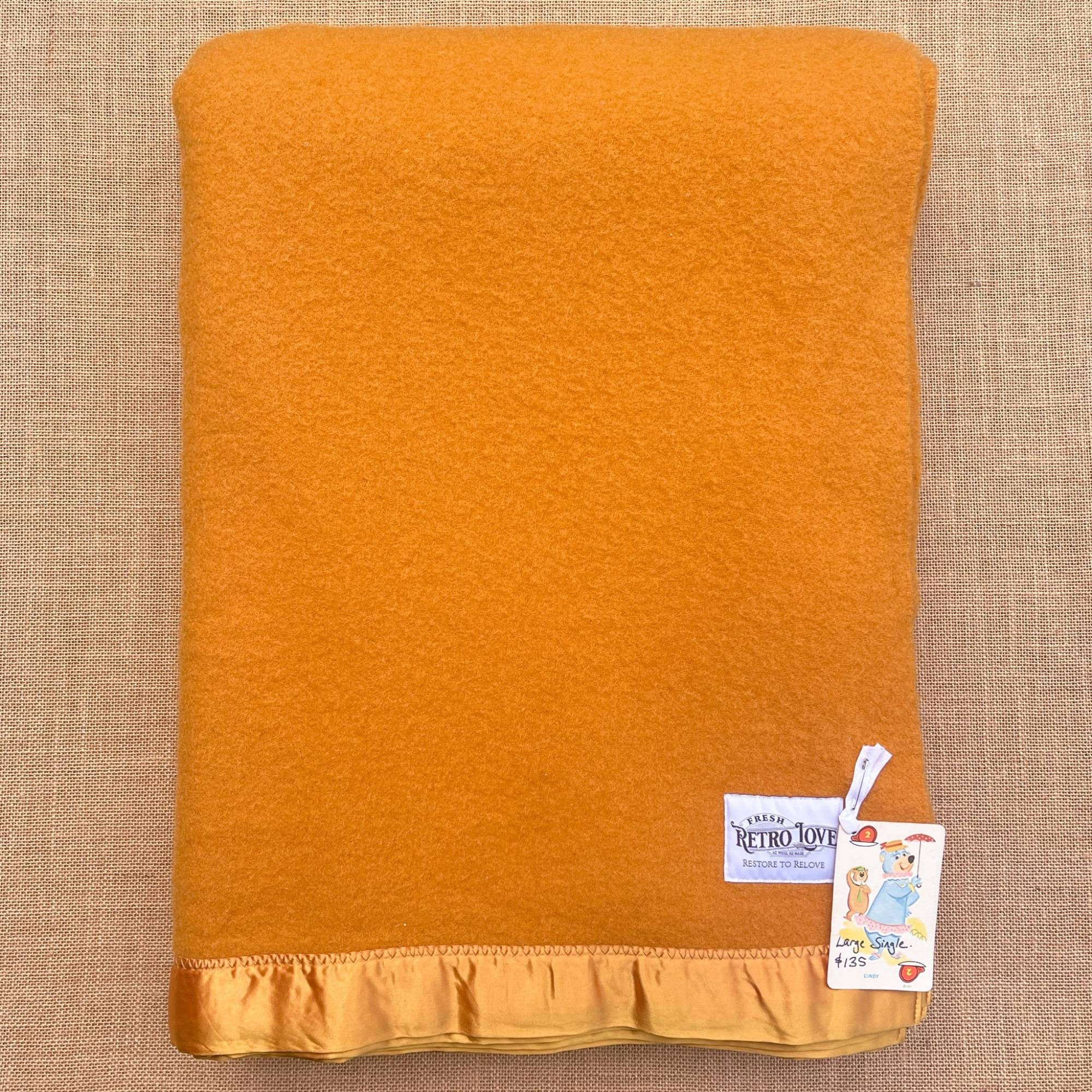 Orange wool blanket with light orange satin trim