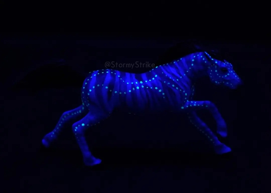 Same model as previously but in the dark. Little dots appear to glow on the body. The mane and tail are not visible against the dark background.