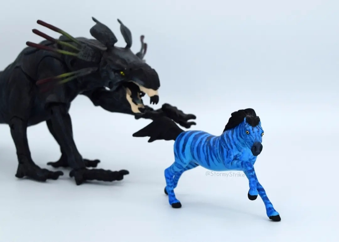 Blue striped stablemate model appears to be running away from a black thantor panther-like creature action figure.