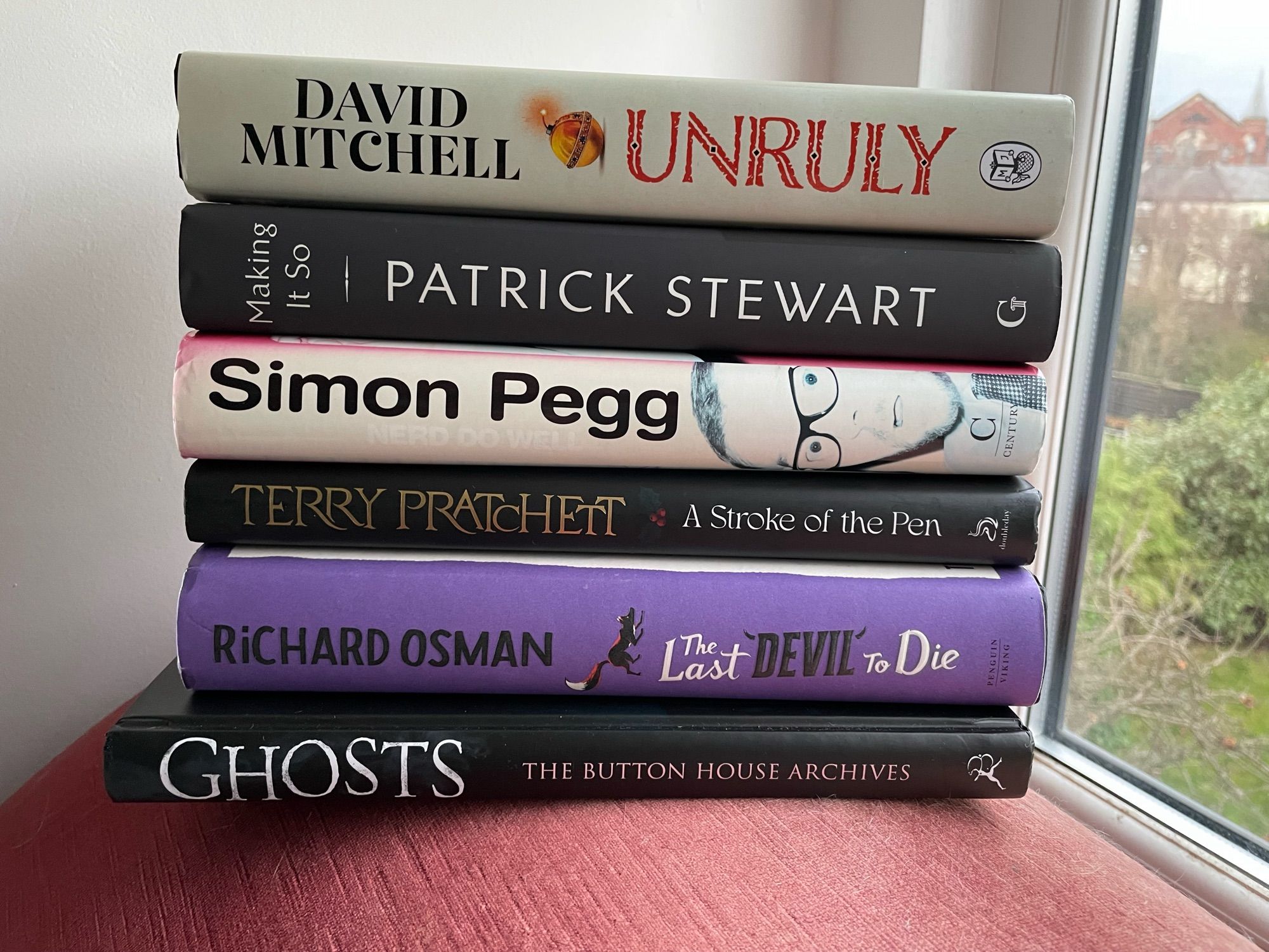 A pile of books
Unruly by David Mitchell
Making it So by Patrick Stewart 
Nerd Do Well by Simon Pegg
A Stroke of the Pen by Terry Pratchett 
Last Devil to Die by Richard Osman
The BBC Ghosts companion