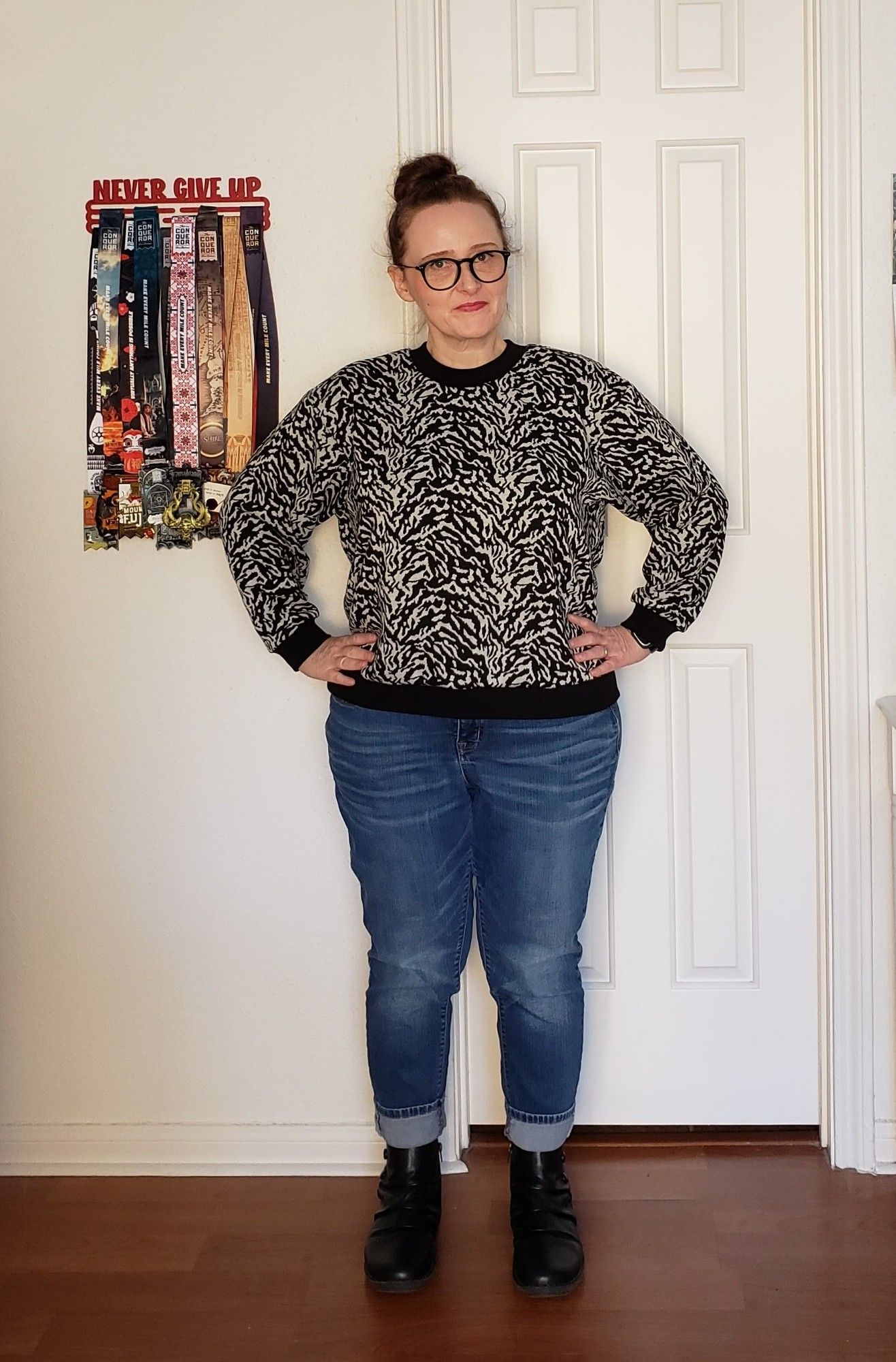 Sarah, a short, plump person, stands proudly wearing jeans and a zebra print sweatshirt she made herself.