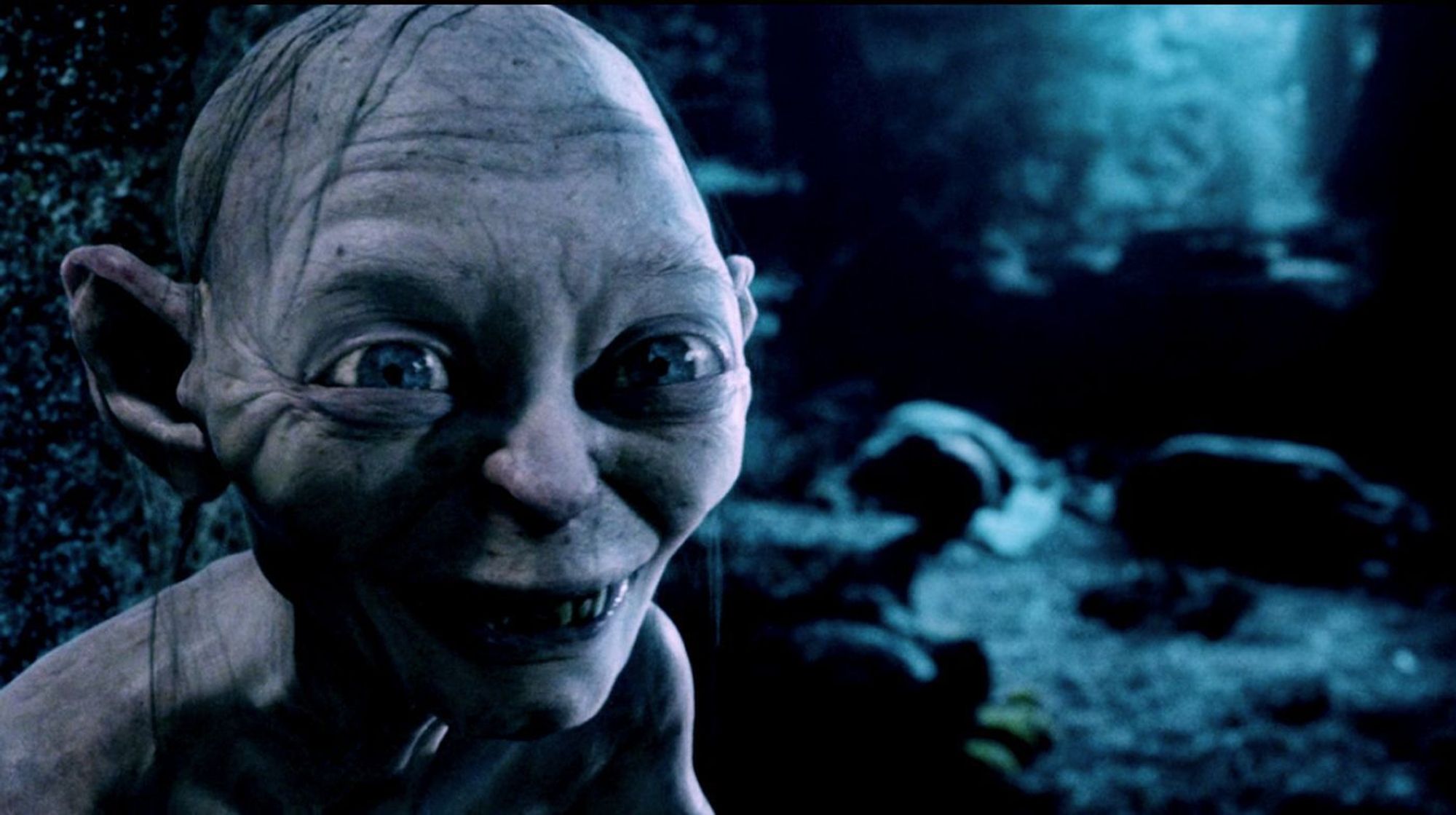 Gollum, all big eyes, bad teeth and the thinnest comb-over, looking shifty in cave scene from Lord of the Rings.