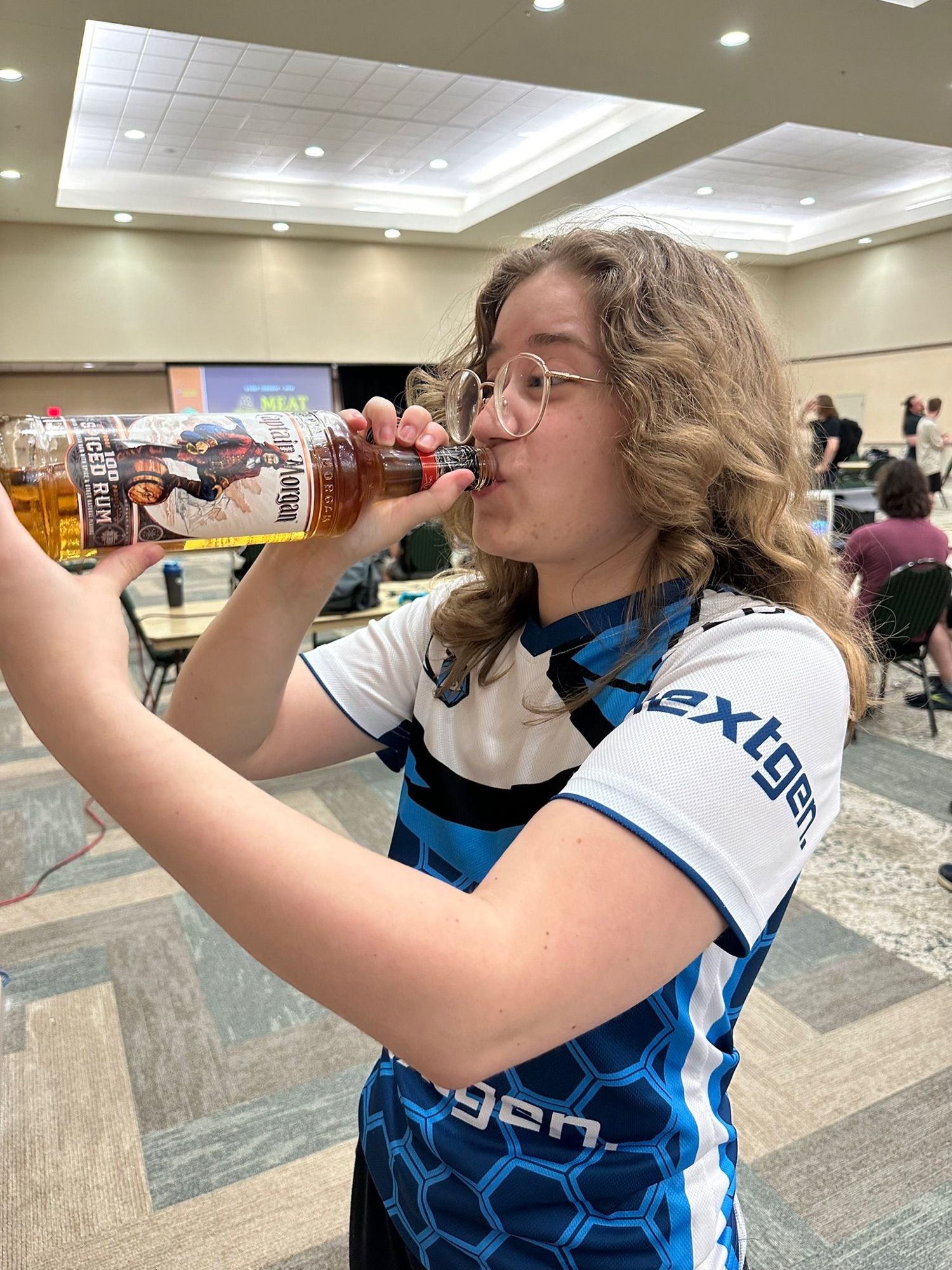 Sp1nda standing in a Melee tournament venue while drinking a bottle of 100 proof Captain Morgan straight from the handle. 