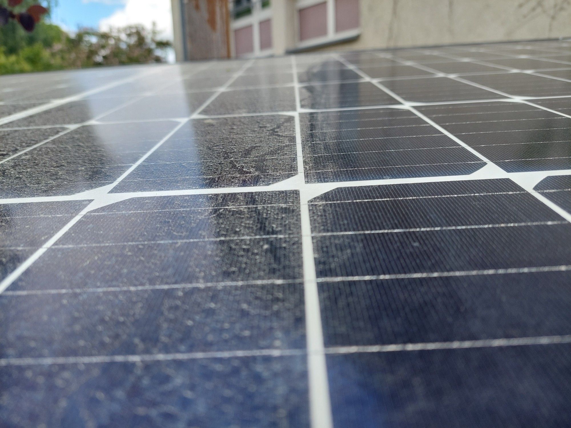 Solarmodul eines Balkonkraftwerks, zur Hälfte geputzt